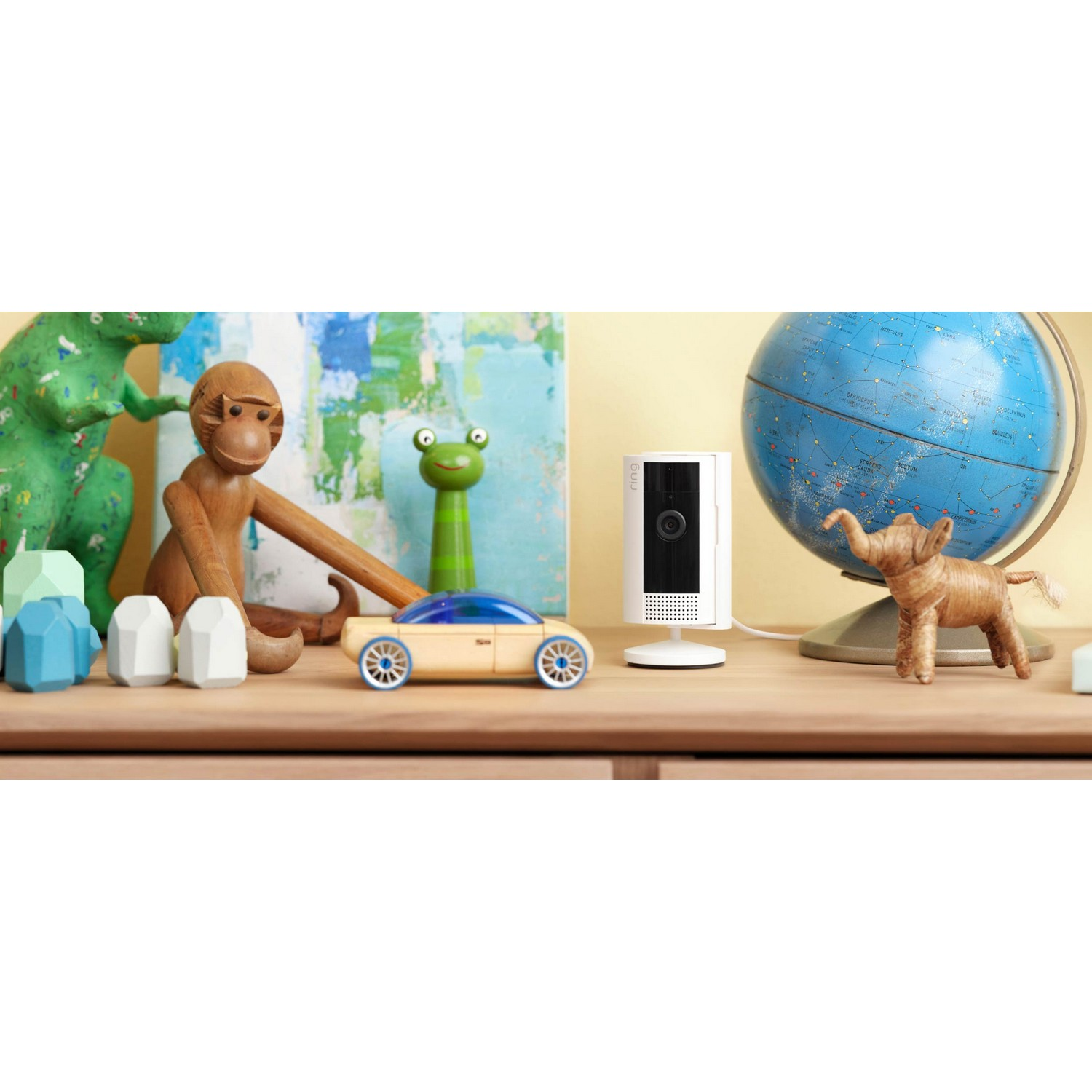 Wooden toys and a Ring camera on a wooden surface.