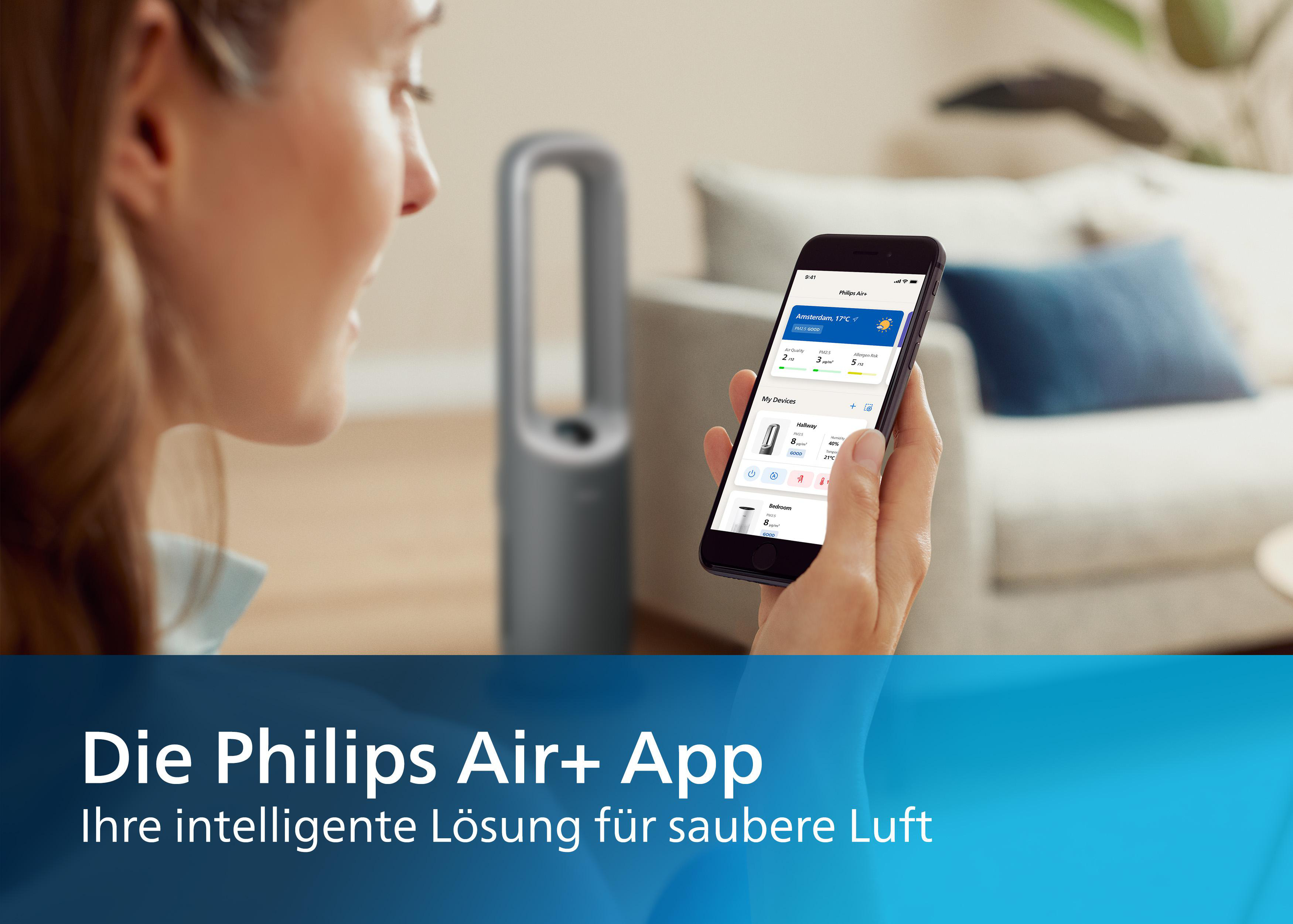 Eine Frau benutzt ihr Telefon mit einer App. Ein Luftreiniger ist im Hintergrund. Text: 'Die Philips Air+ App'.