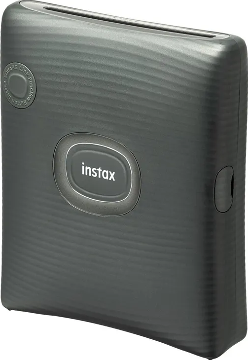 Una stampante Instax grigio scuro. Ha il logo instax, un pulsante quadrato e una fessura in alto.
