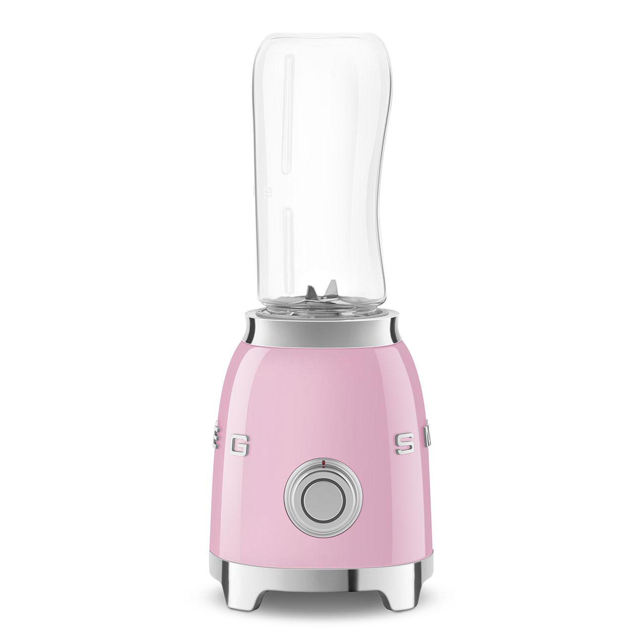 Ein rosa Smeg-Mixer mit einem transparenten Behälter auf weißem Hintergrund.