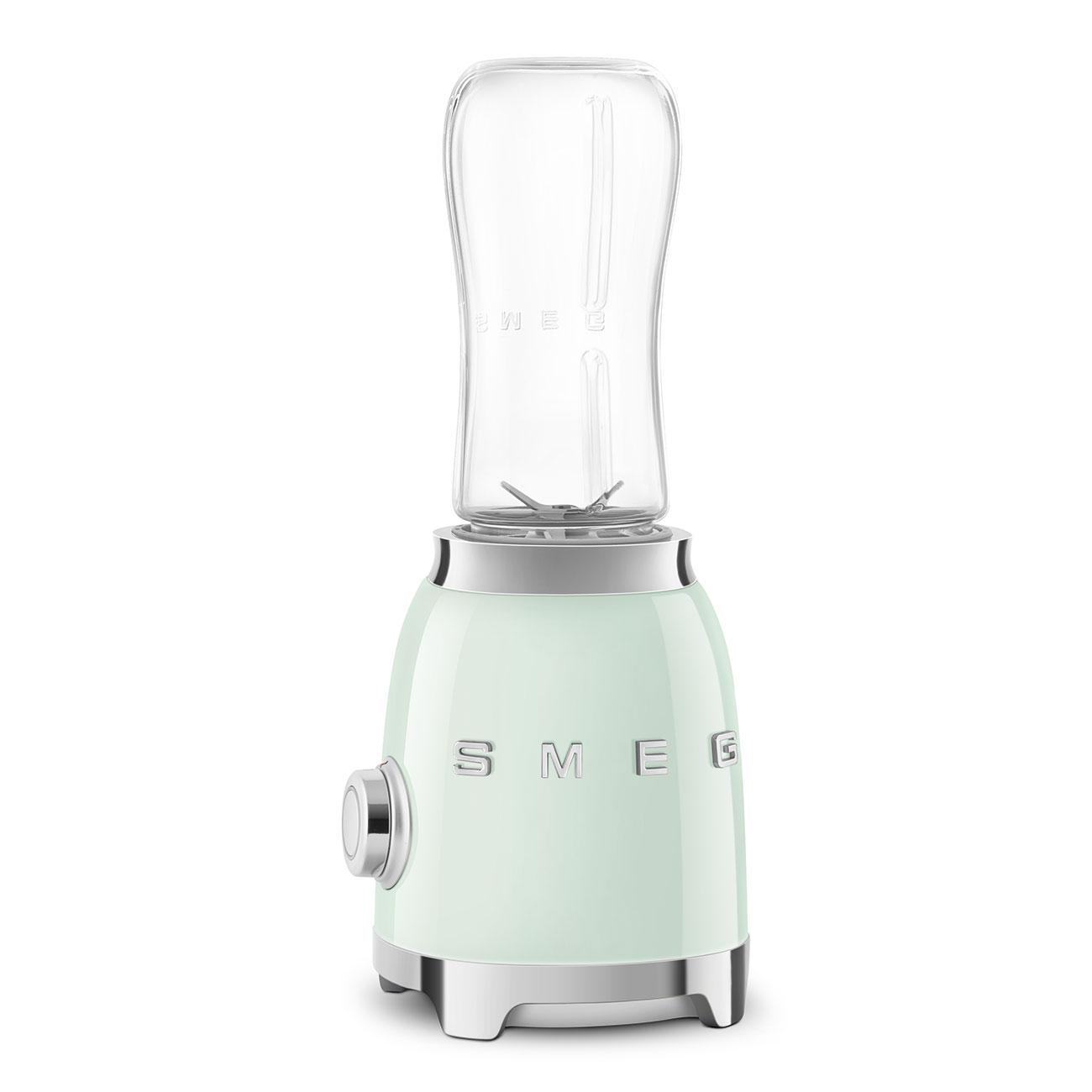 Ein mintgrüner Smeg-Mixer mit einem transparenten Behälter oben, isoliert auf Weiß.