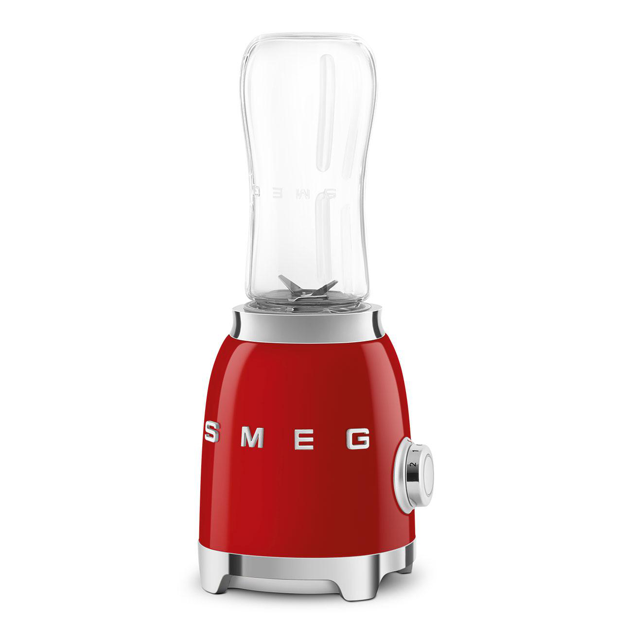Ein roter Mixer mit einem transparenten Behälter, auf weißem Hintergrund.