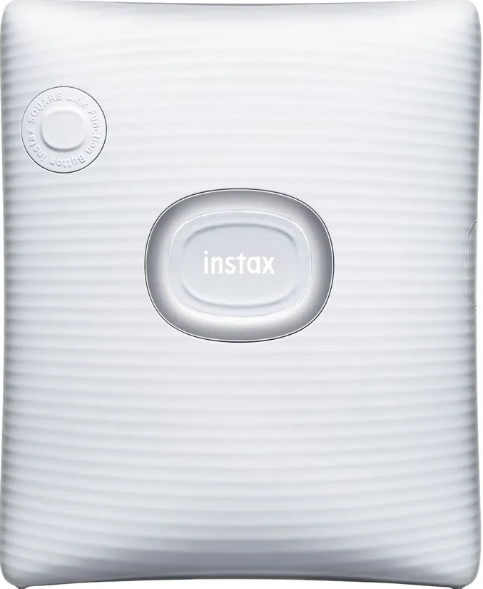 Fotocamera Instax bianca. Ha un obiettivo ovale e un pulsante quadrato.