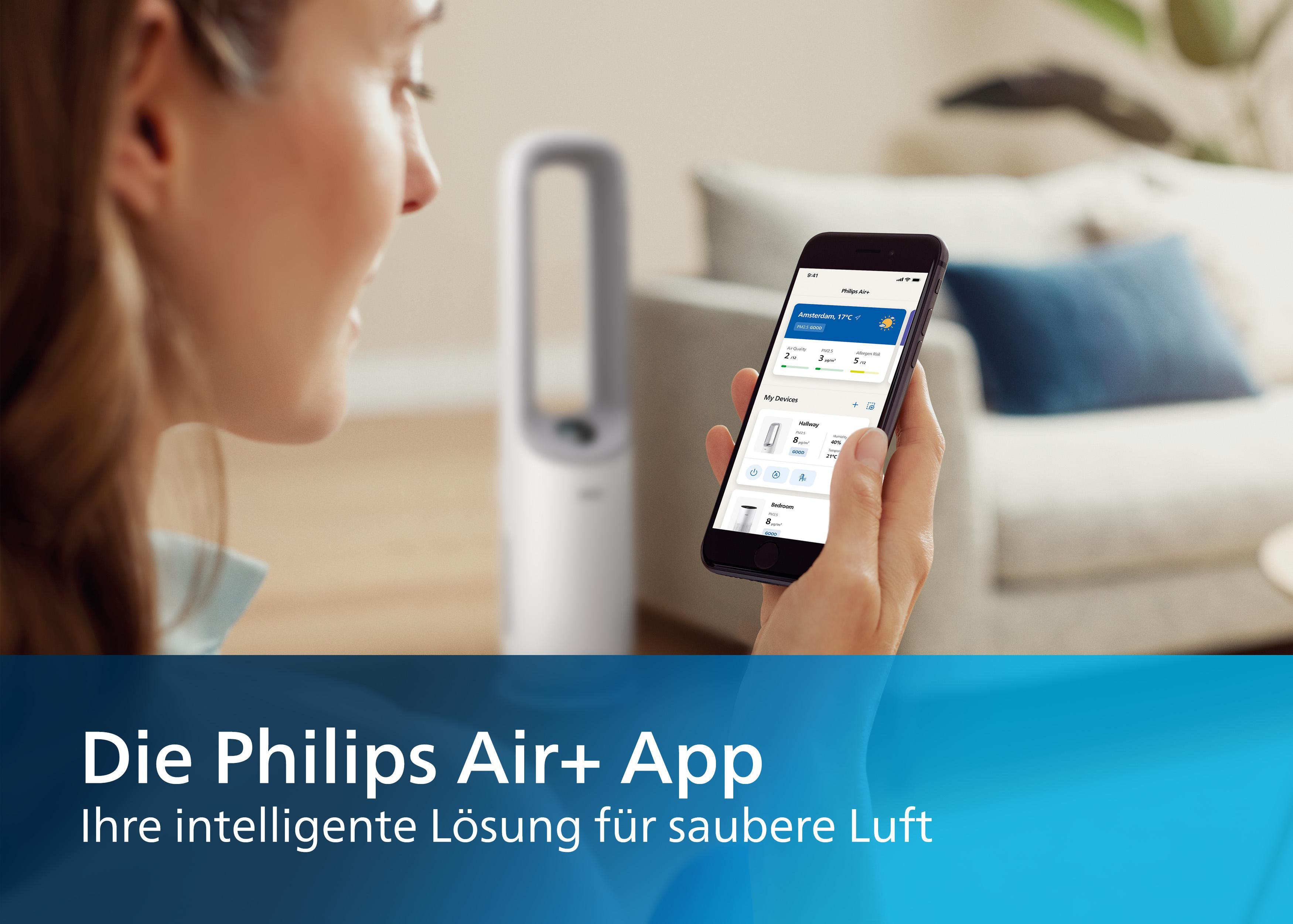 Eine Frau benutzt eine App auf ihrem Telefon, um den Luftreiniger zu steuern. Ein Luftreiniger ist im Hintergrund.