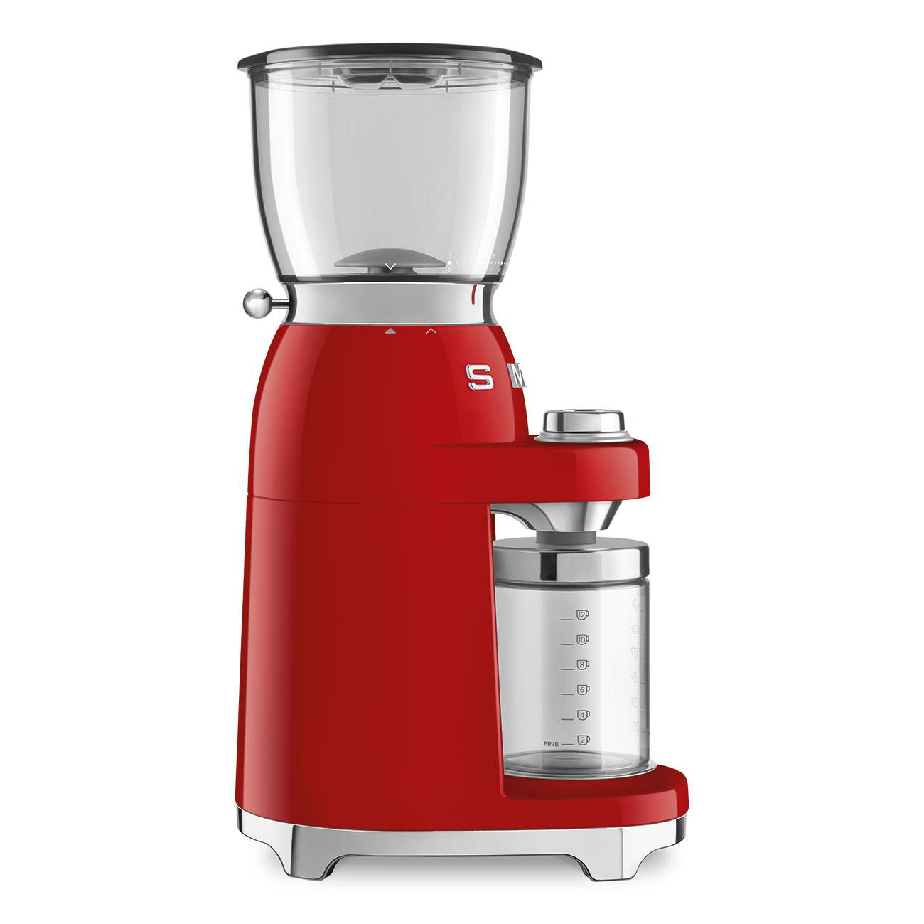 Ein roter Smeg-Kaffeemühle steht auf einer weißen Oberfläche, mit einem transparenten Bohnenbehälter und einem Glas.