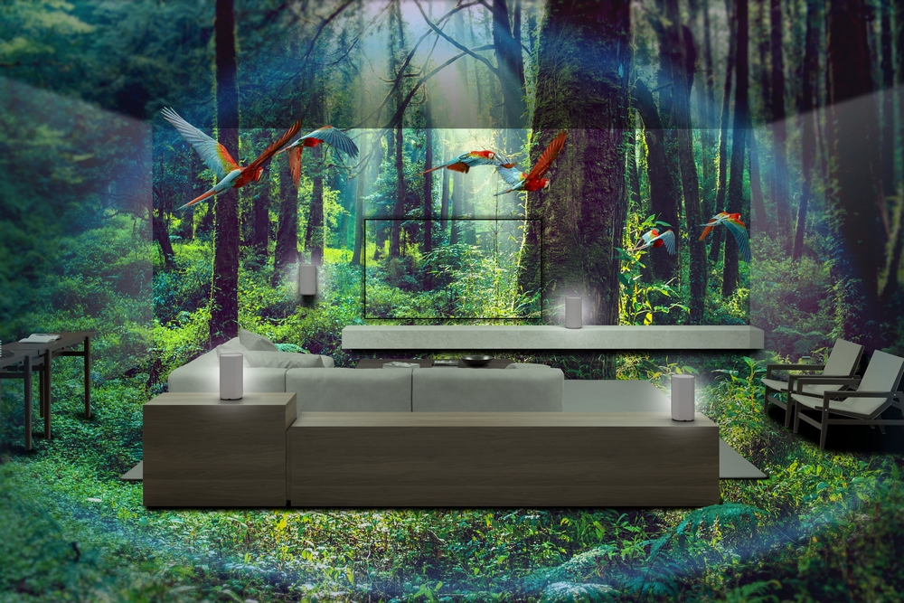 Diseño interior con fondo de bosque y aves tropicales. Sofá y altavoces en primer plano.