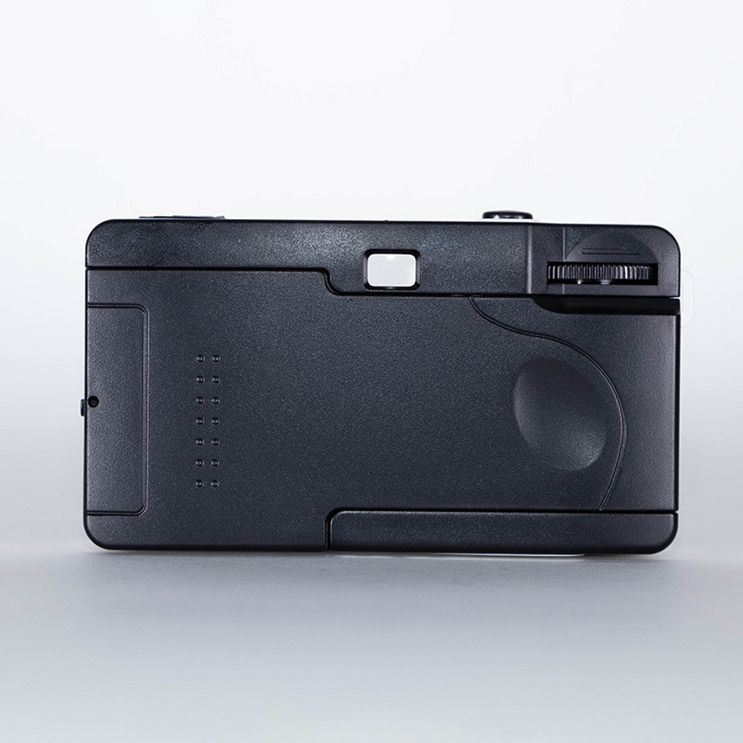 Black retro camera, back view. It has a viewfinder and a winding wheel.