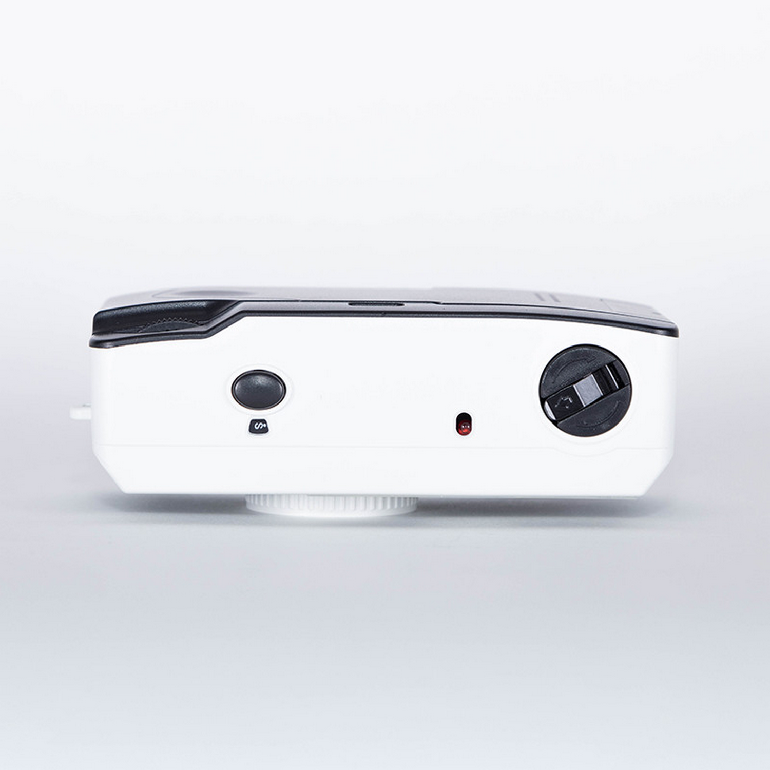 White point-and-shoot camera, top view, with buttons and lens.