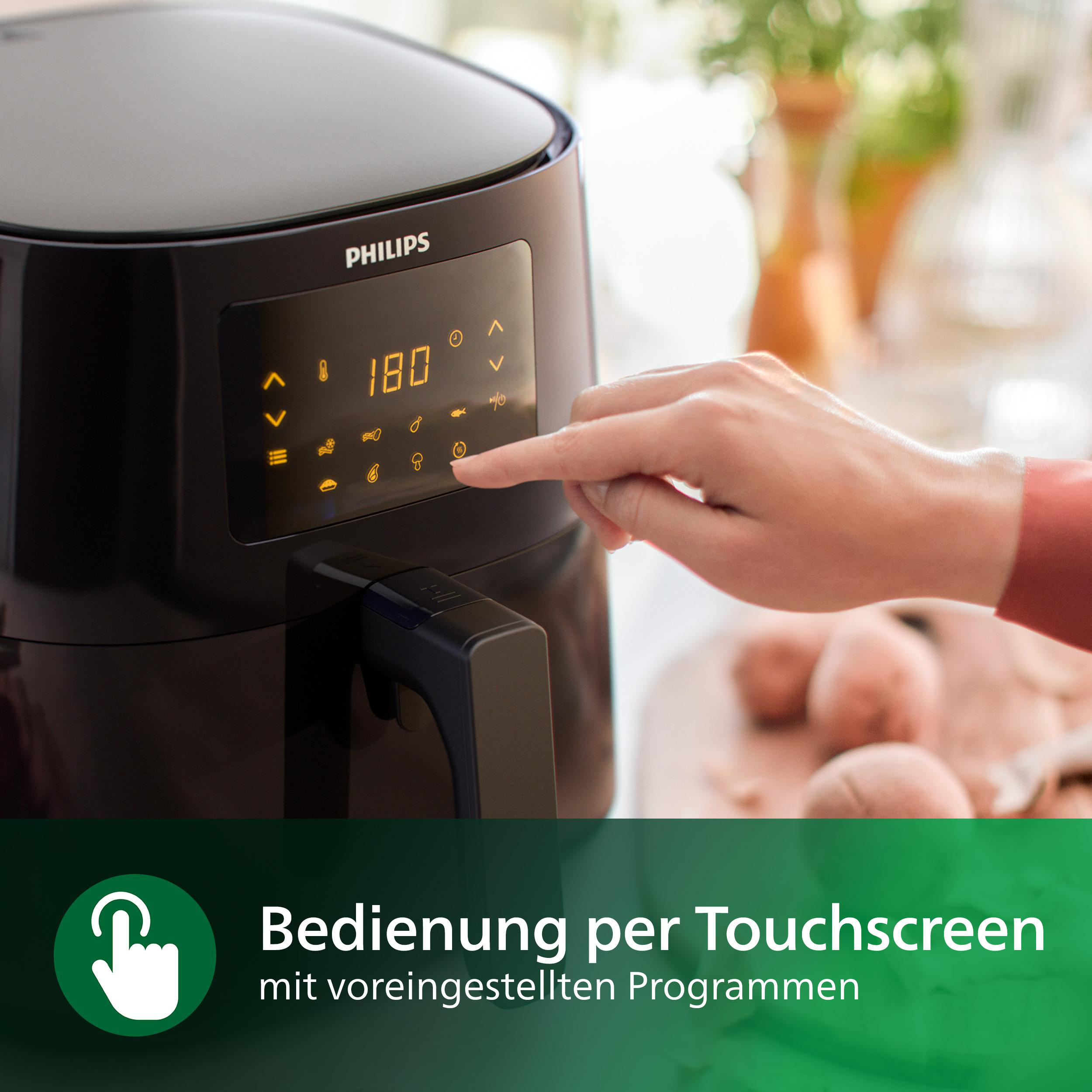 Die Hand einer Person berührt den Touchscreen einer schwarzen Heißluftfritteuse, eingestellt auf 180 Grad.
