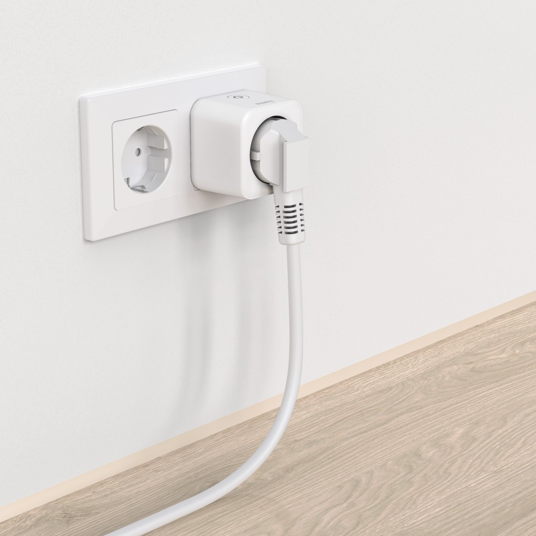 Weißer Smart Plug in einer Steckdose. Eine weitere Steckdose ist daneben leer.