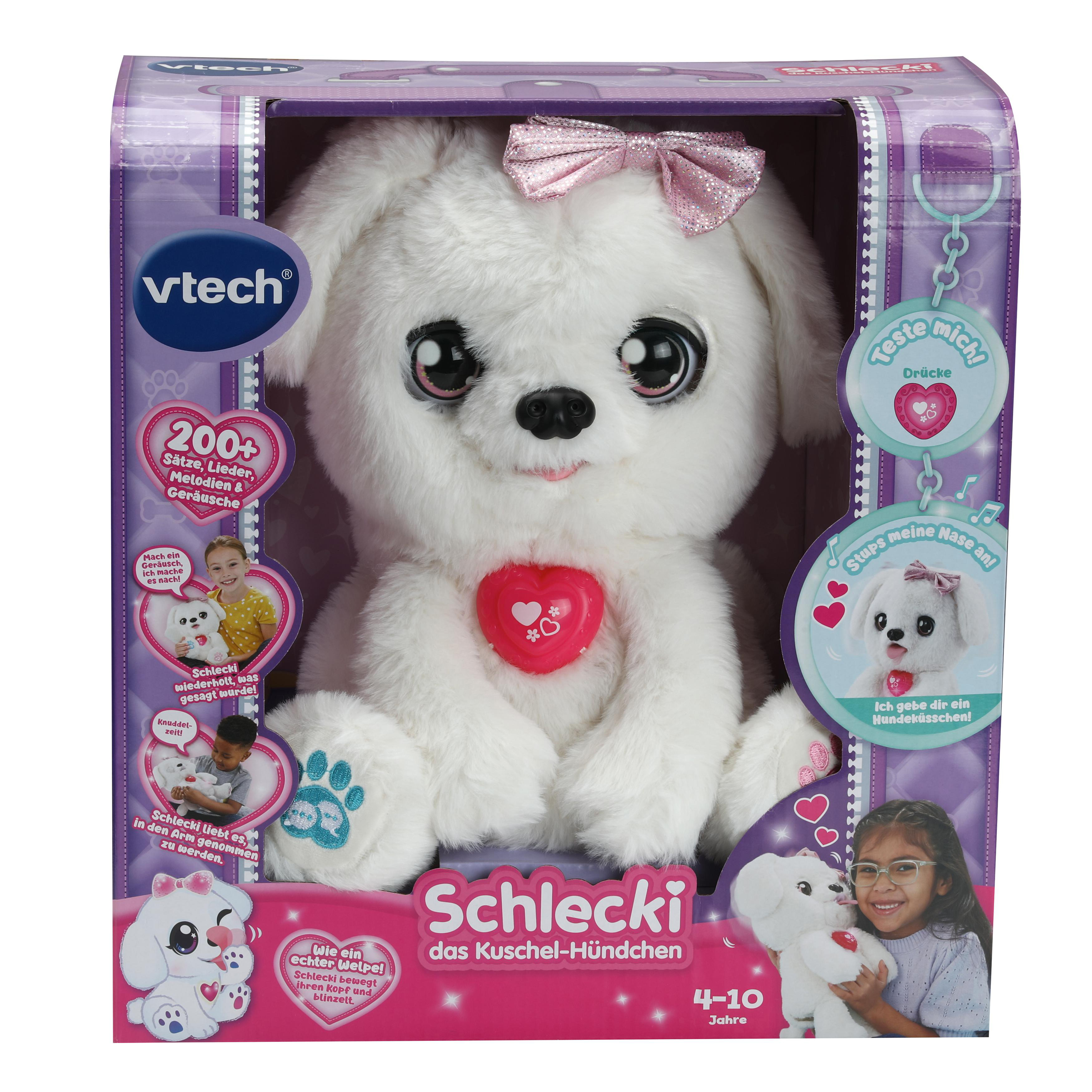 Ein VTech Schleckie interaktiver Spielzeughund in einer Box. Weißer Hund mit rosa Schleife. Mädchen hält es.