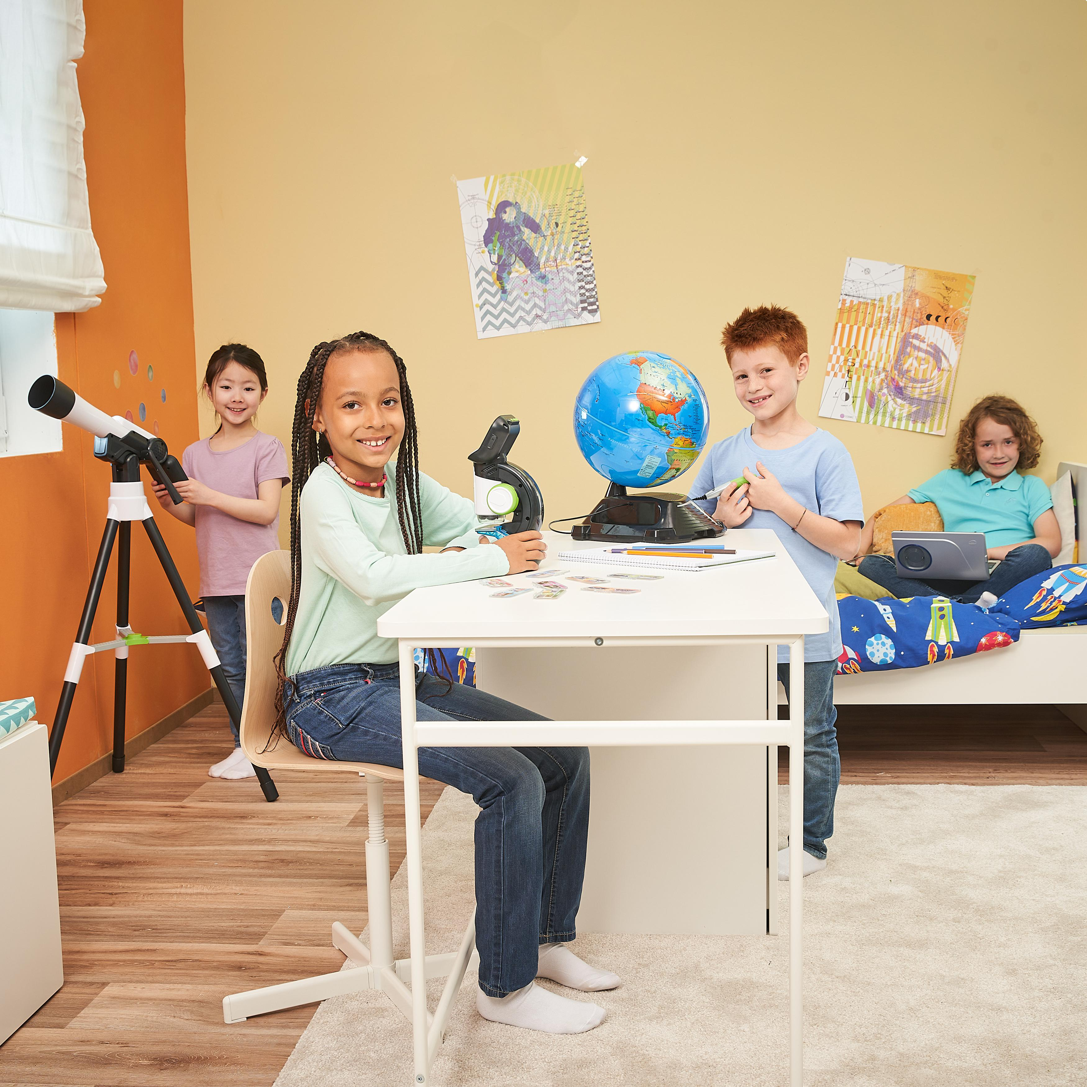 Vier Kinder an einem Schreibtisch mit Globus und Teleskop in einem farbenfrohen Raum.