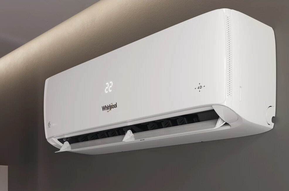 Biały klimatyzator Whirlpool na szarej ścianie, wyświetlający 22. Urządzenie ma elegancki, nowoczesny design.