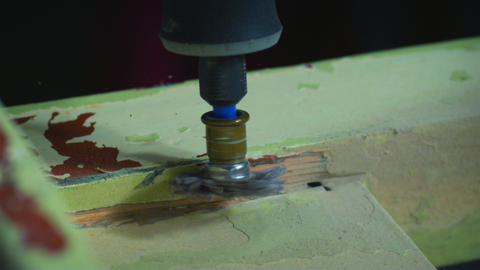A Dremel szerszám eltávolítja a festéket a fából.