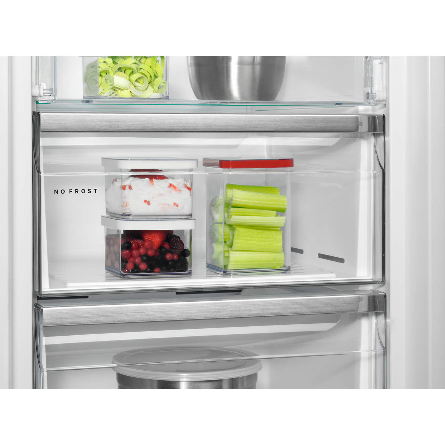 Primo piano dell'interno di un frigorifero con ripiani contenenti alimenti. Testo 'NO FROST' visibile.