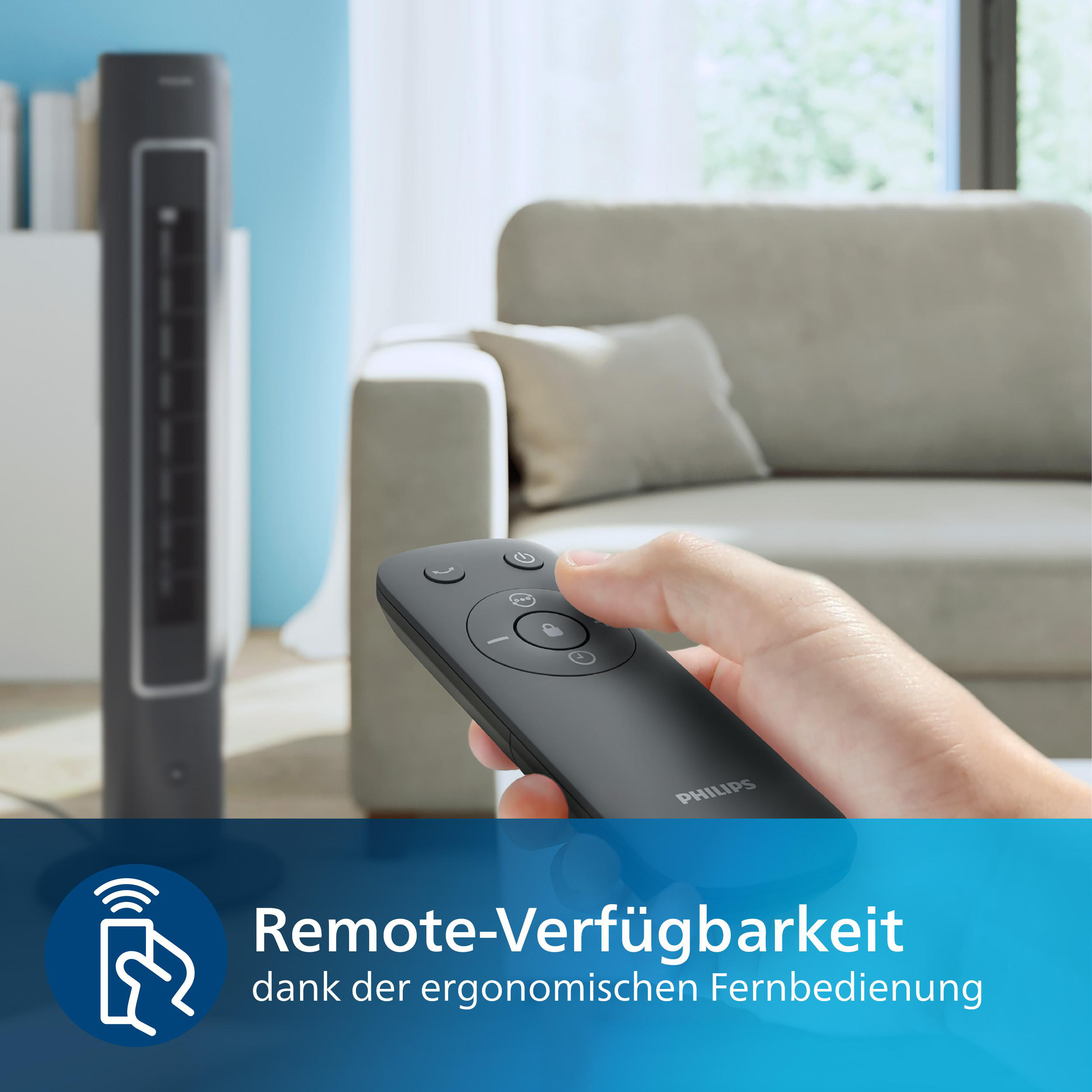 Hand hält schwarze Fernbedienung, Lüfter dahinter. Couch im Hintergrund.