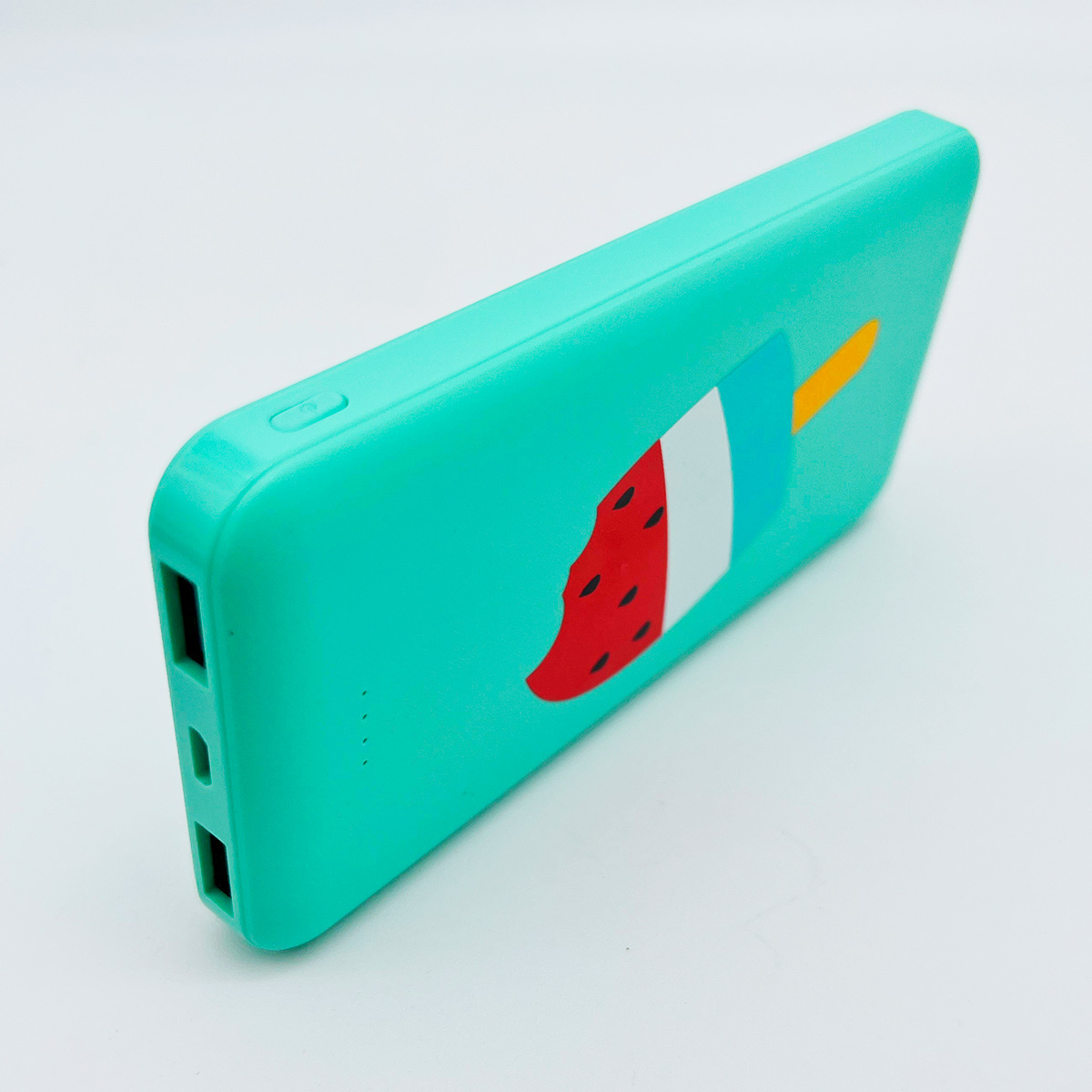 Un power bank verde con diseño de paleta. Tiene puertos de carga y un botón de encendido.
