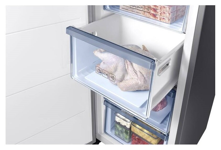 Szuflada zamrażarki otwarta z kurczakiem w środku i innymi przedmiotami.