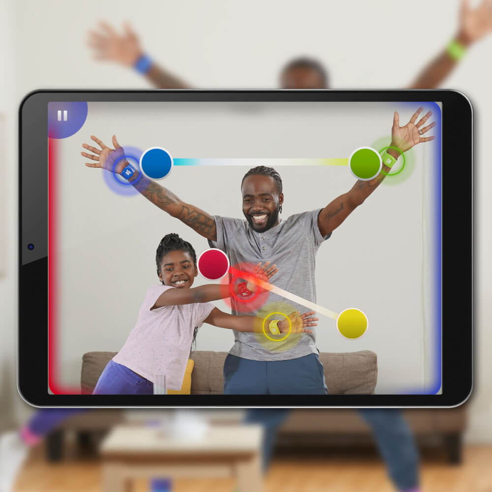 Vater und Tochter spielen ein Spiel auf einem Tablet, mit verbundenen Armbändern.