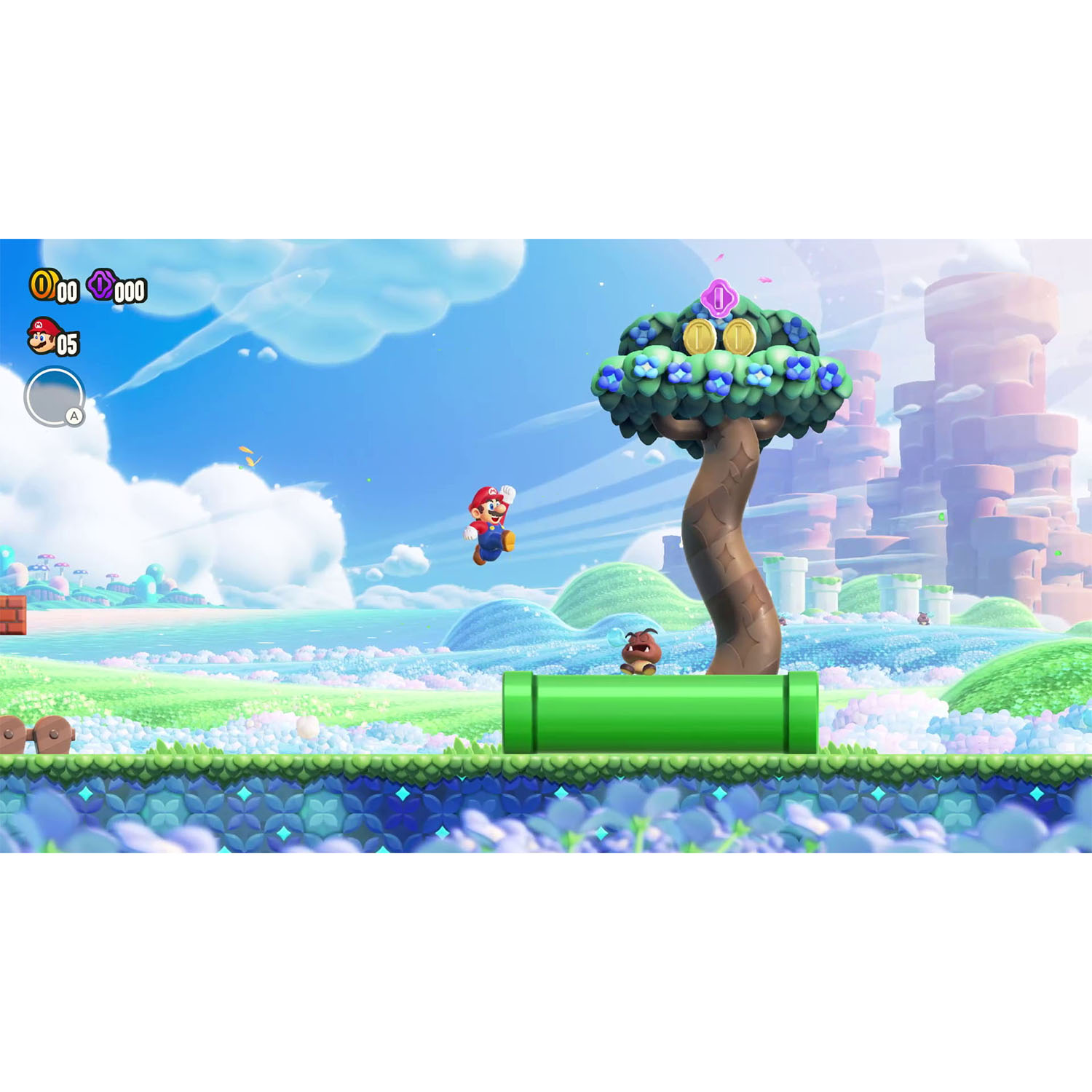Mario salta in un livello colorato con monete, un albero, un tubo verde e un Goomba.