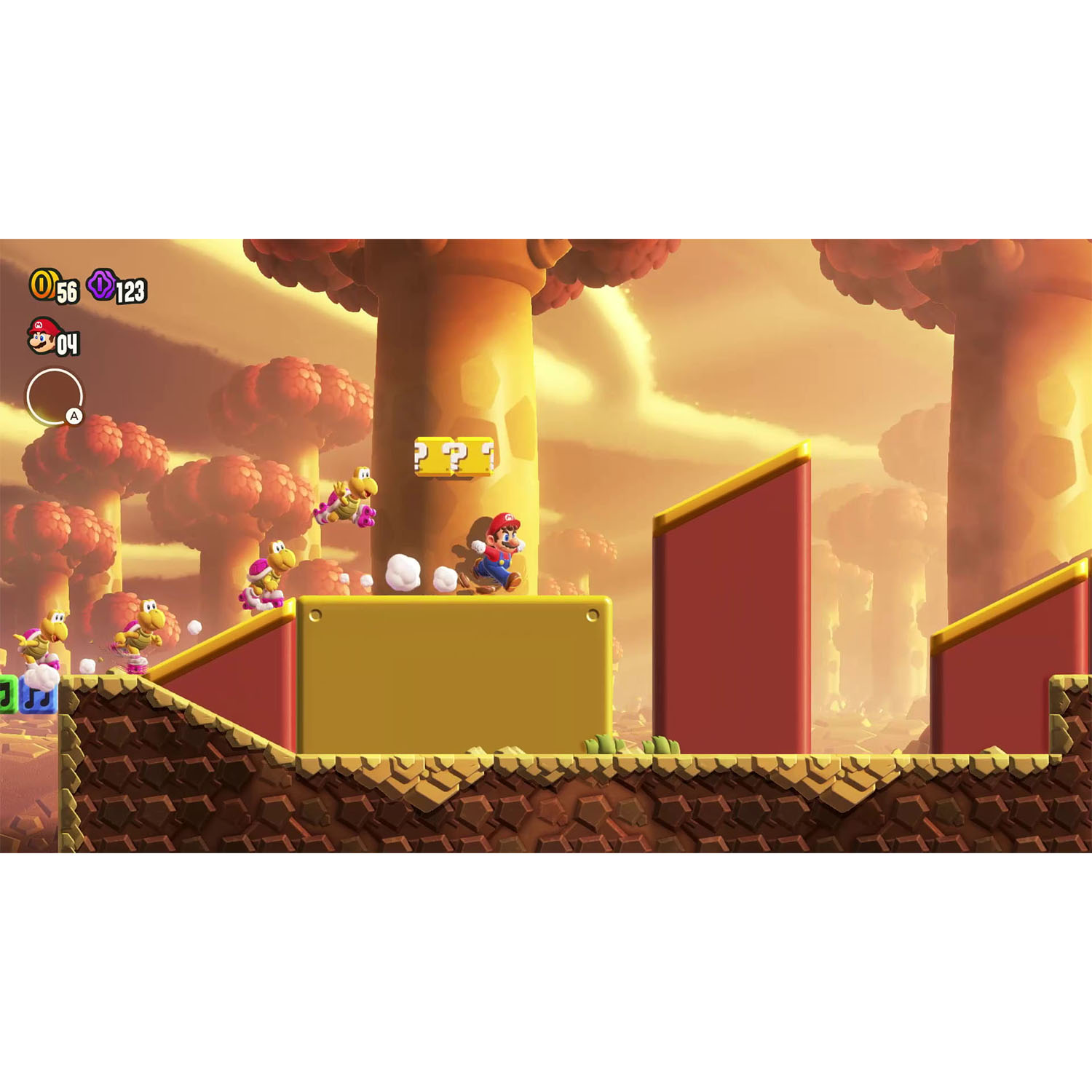 Mario salta su un blocco con i Koopa Troopas. Piattaforme dorate e rosse, alberi e cielo riempiono lo sfondo.