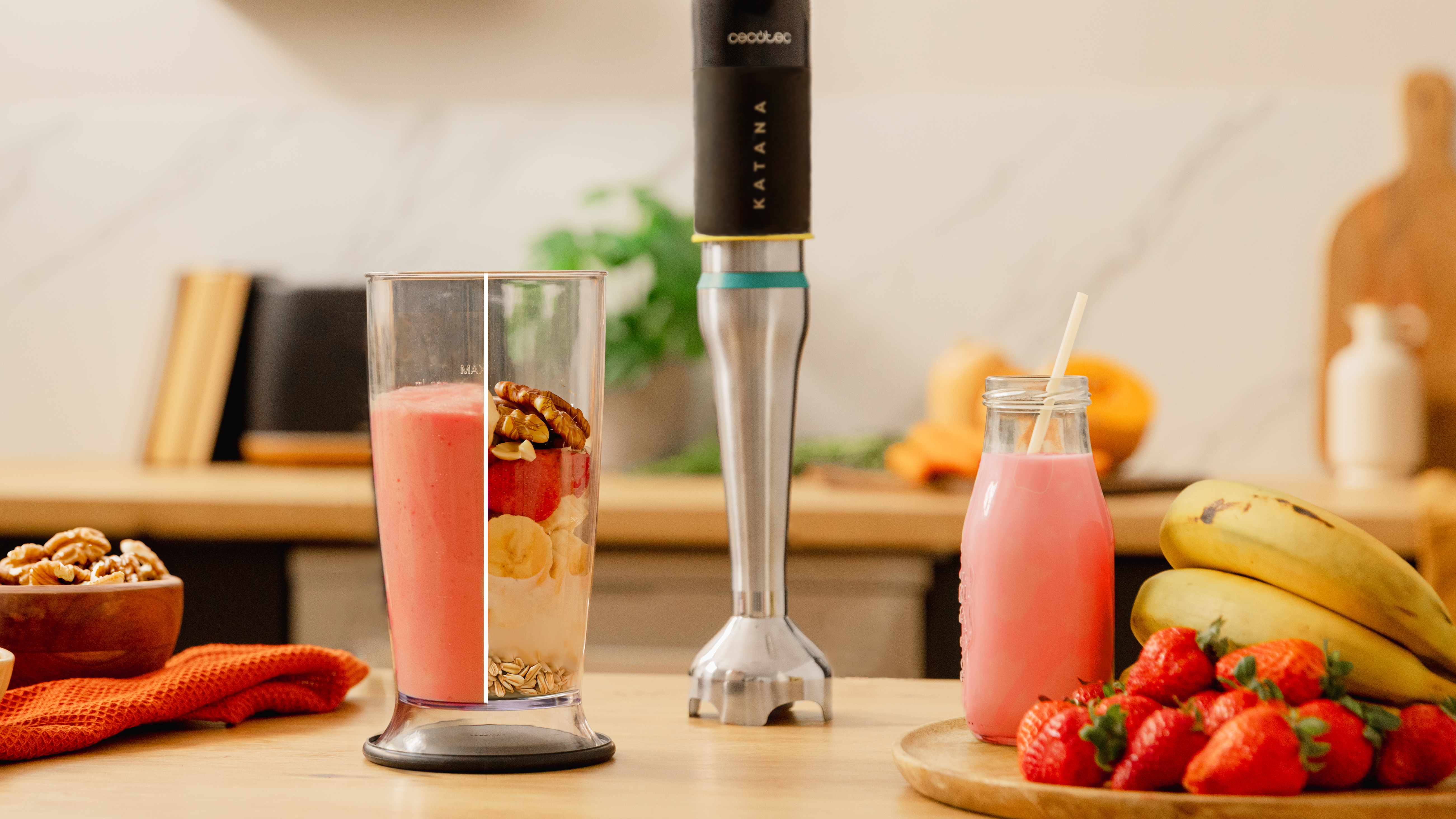 Una preparación de batido con una licuadora, un vaso de batido e ingredientes como fresas y plátanos.