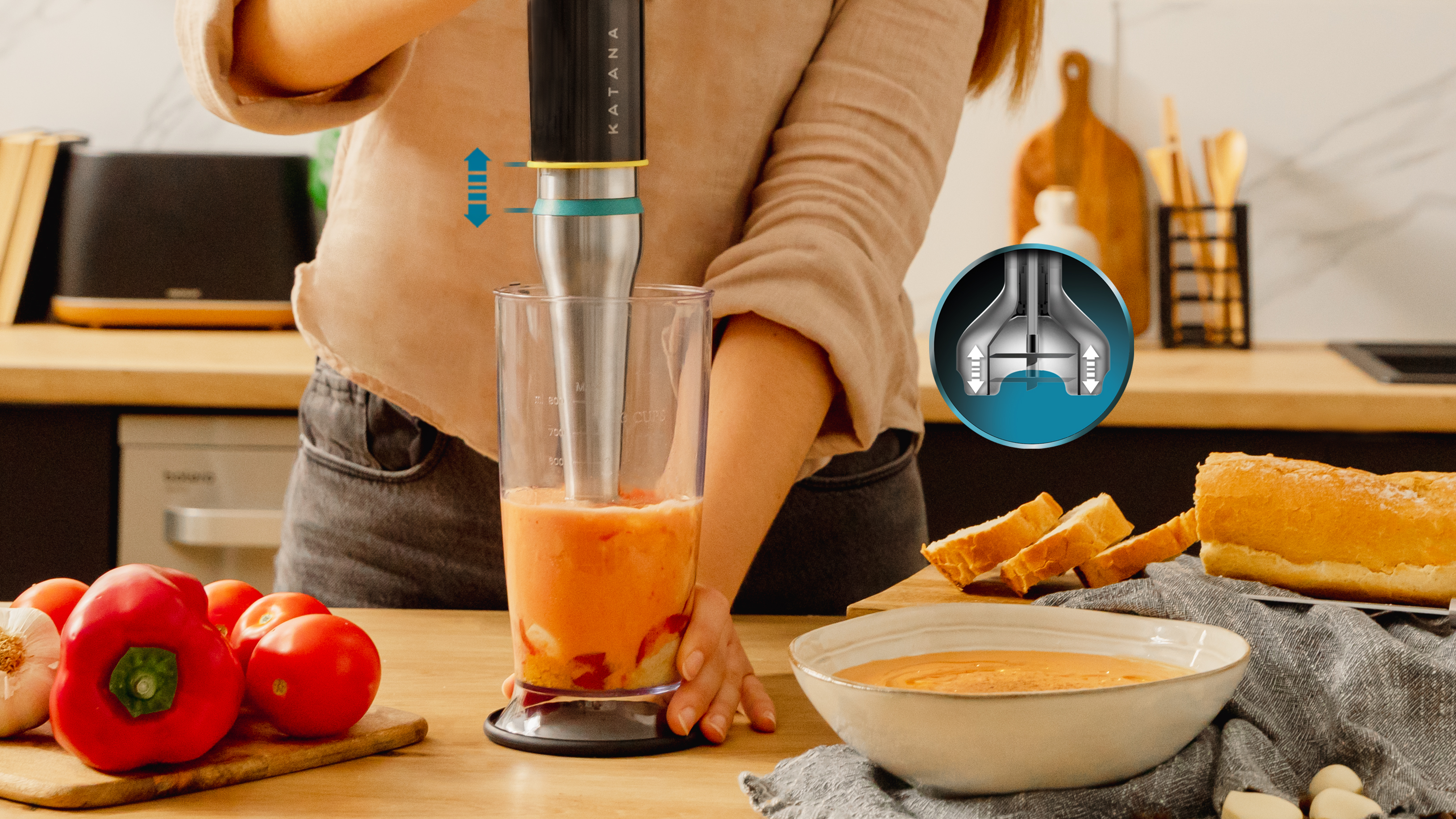 Una mujer está mezclando ingredientes en un vaso con una batidora de inmersión Katana.