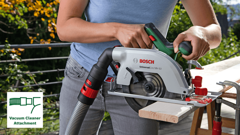 Nő Bosch körfűrészt használ porszívó csatlakozással a fán.