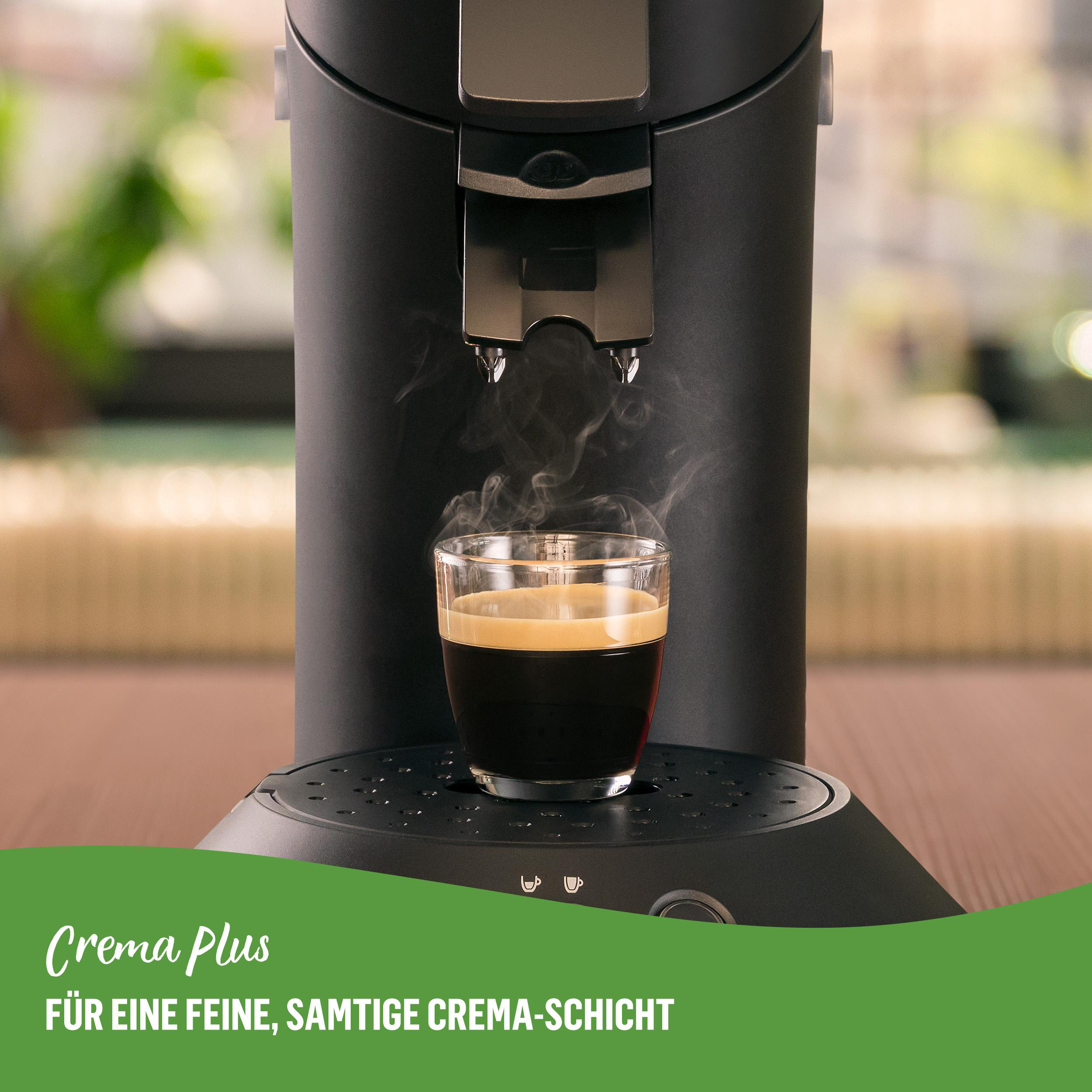 Kaffeemaschine, die Kaffee in ein Glas gießt. Text: 'Crema Plus'.