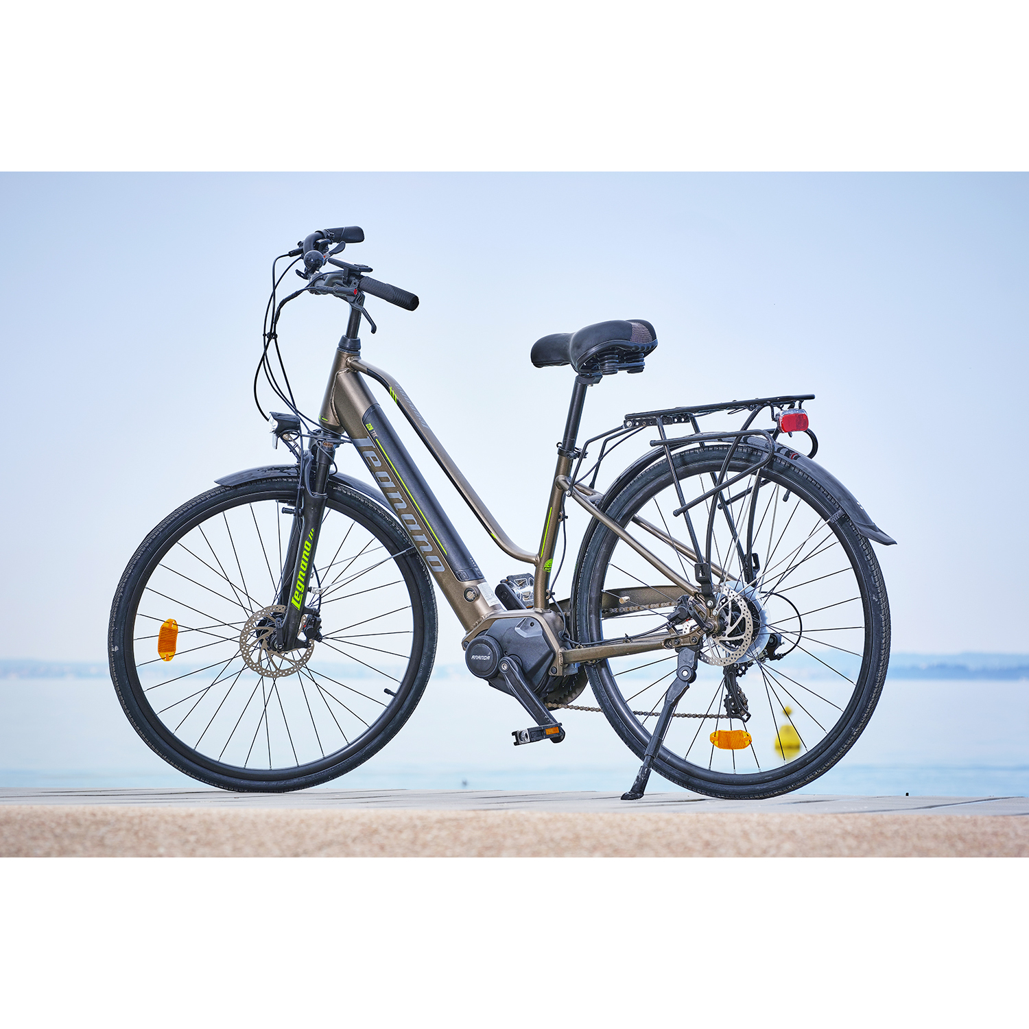 Una bici marrone su una piattaforma vicino all'acqua. Il cielo è blu.
