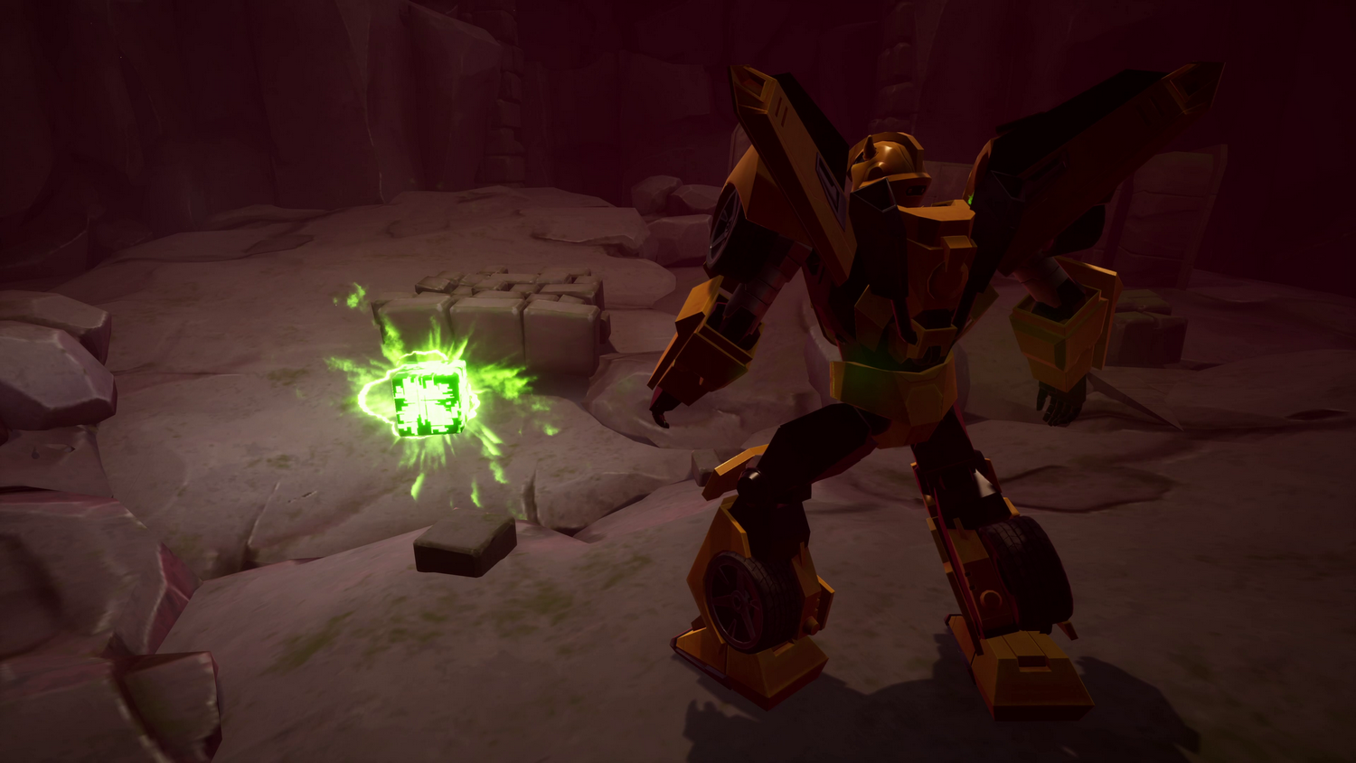 Un robot Transformer amarillo frente a un cubo verde brillante en un entorno oscuro y rocoso.