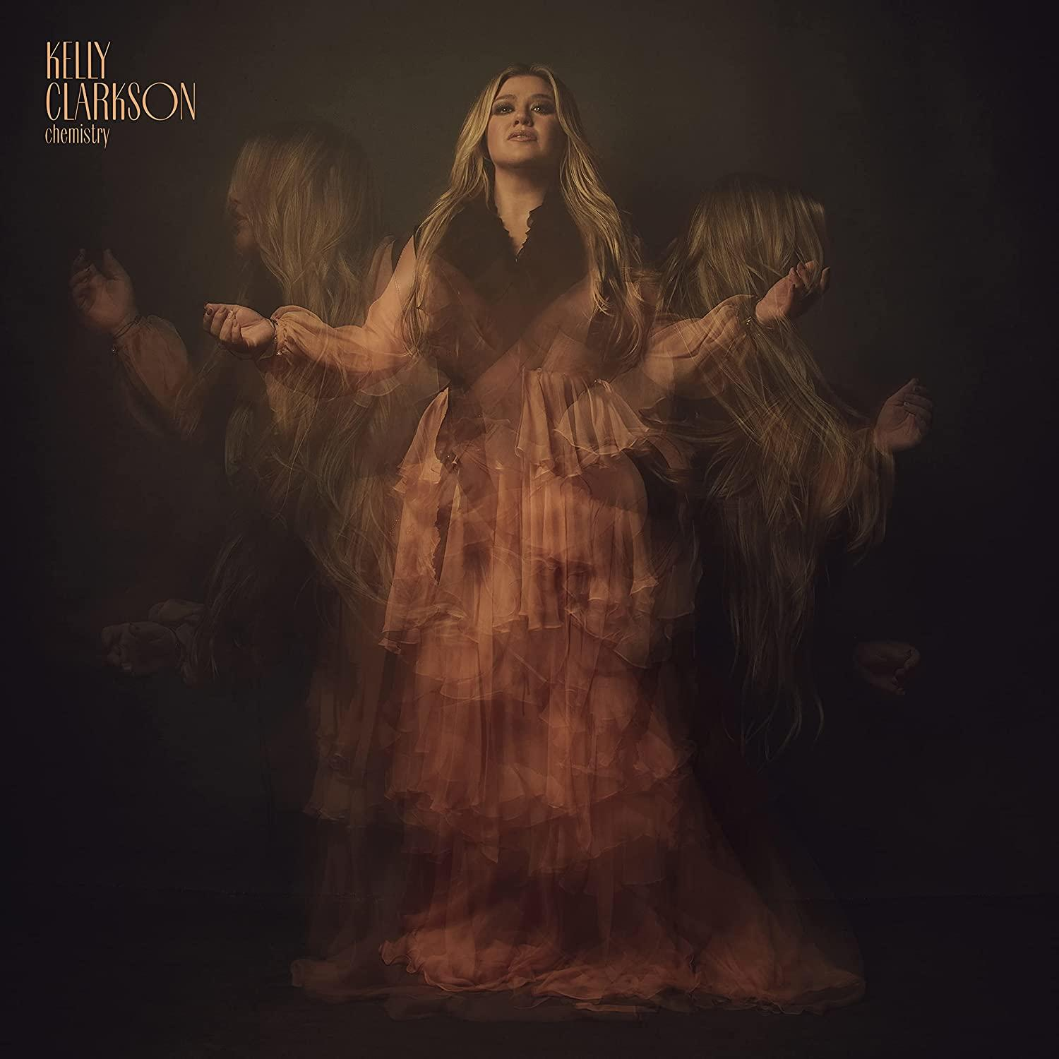 Albumcover: Kelly Clarkson in fließendem Kleid, Mehrfachbelichtung, dunkler Hintergrund.