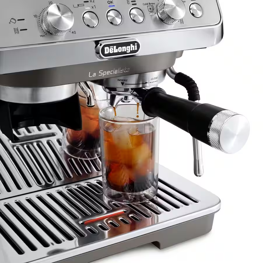 Eine Espressomaschine, die ein Glas Eiskaffee füllt. Die Maschine ist silberfarben mit schwarzem Griff.
