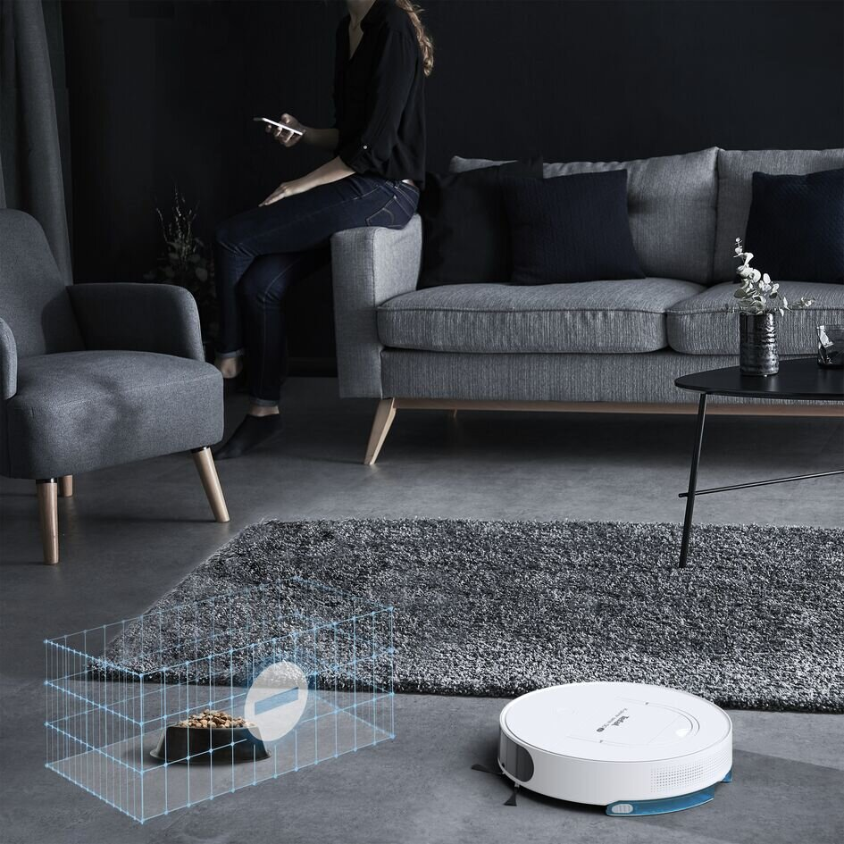 Odkurzacz robot z klatką wokół miski dla zwierząt i szarą matą.
