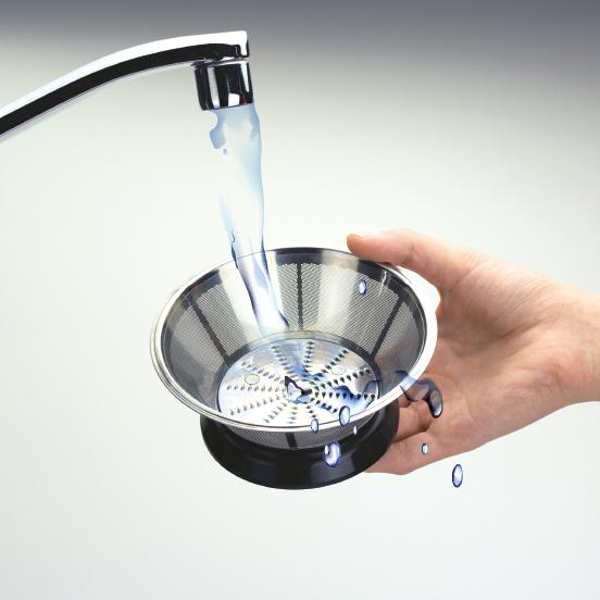 Eine Hand hält ein Metallsieb unter einem Wasserstrahl, der aus einem silbernen Wasserhahn in einem weißen Waschbecken kommt.