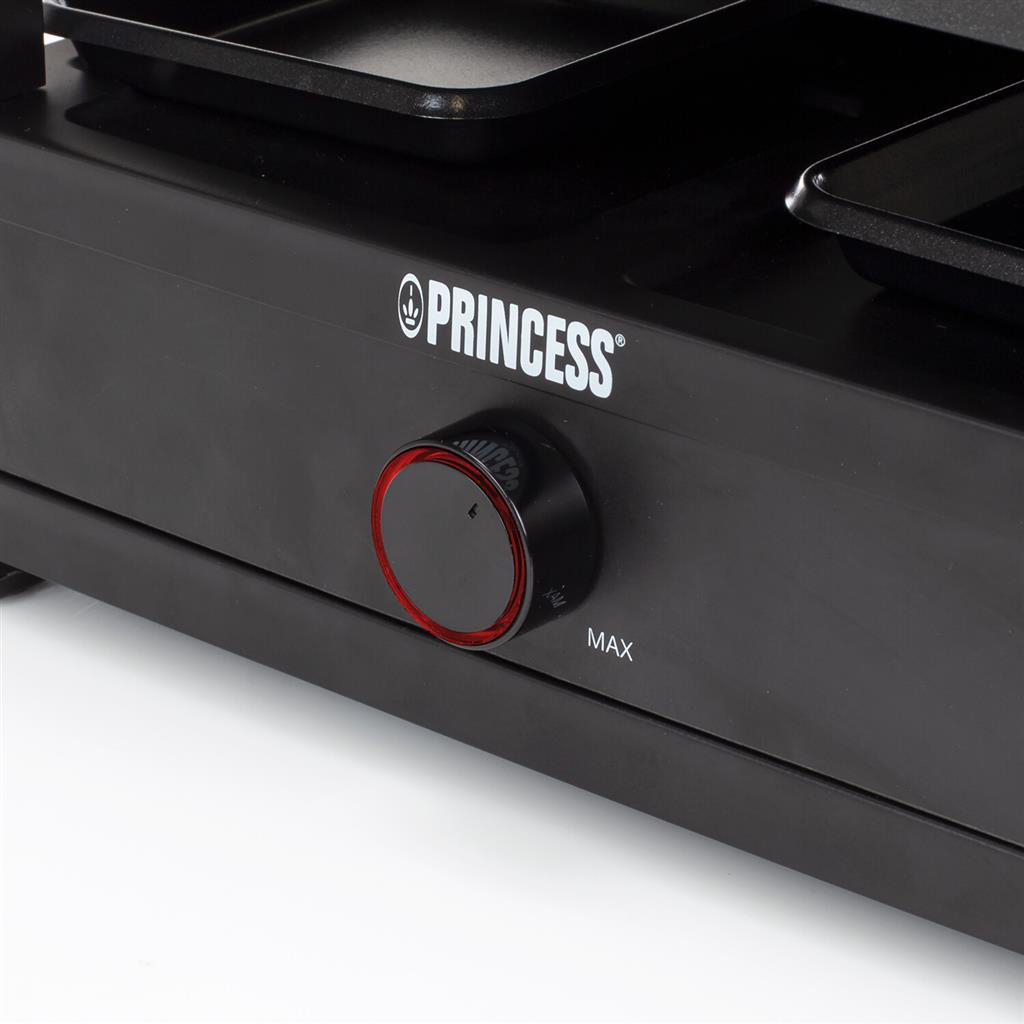 Detail des schwarzen Princess-Raclette-Grills. Verfügt über einen Knopf mit rotem Ring, und der Markenname ist sichtbar. Schwarze Tabletts oben.