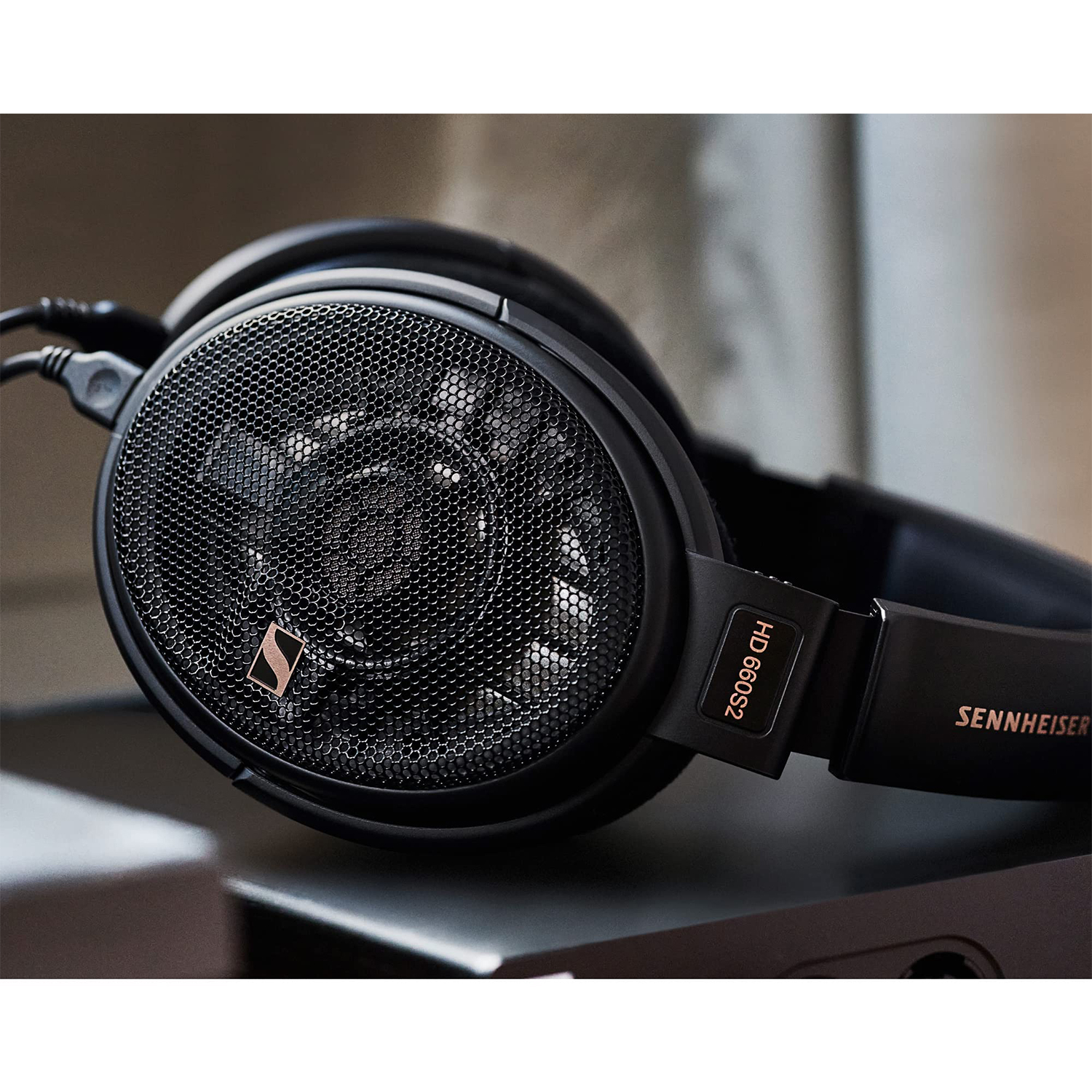 Cuffie nere. Design a rete. Logo Sennheiser. Collocate su una superficie scura, sfondo sfocato.