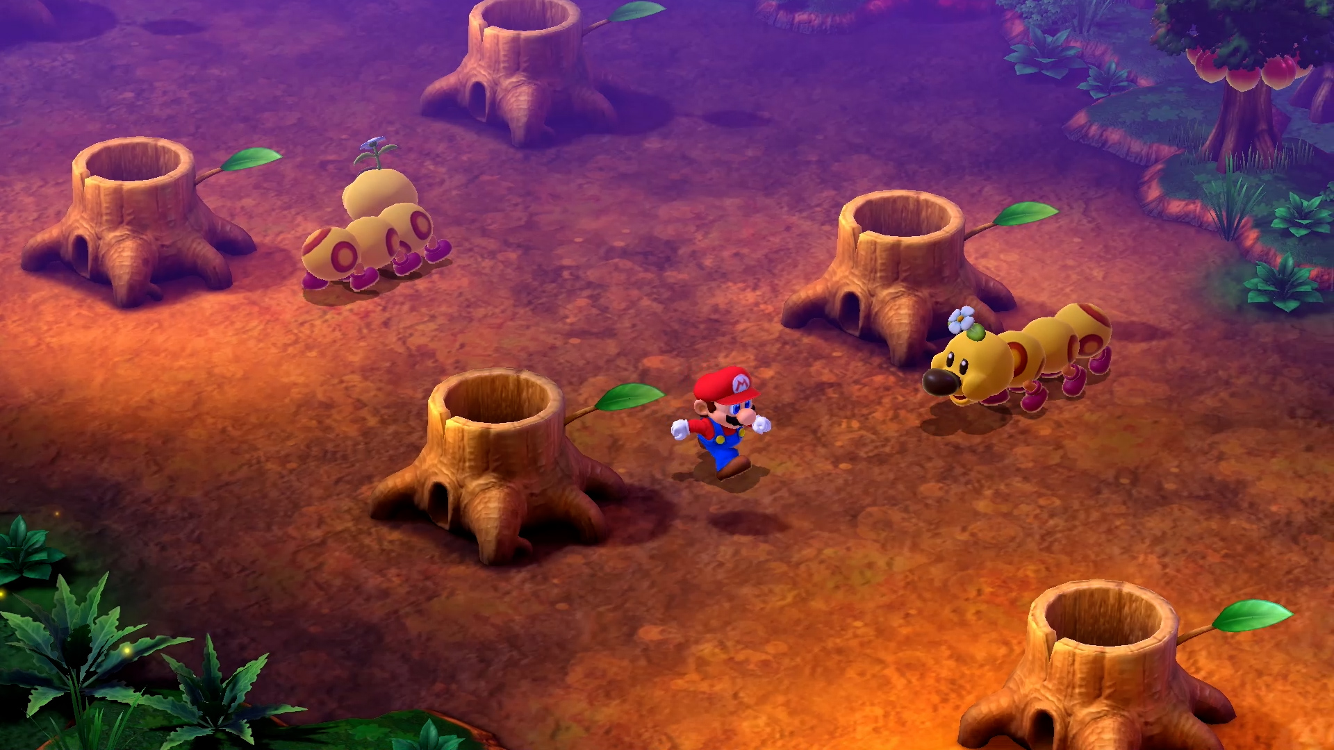 Mario dans une forêt, entre des souches, avec des créatures chenilles jaunes.