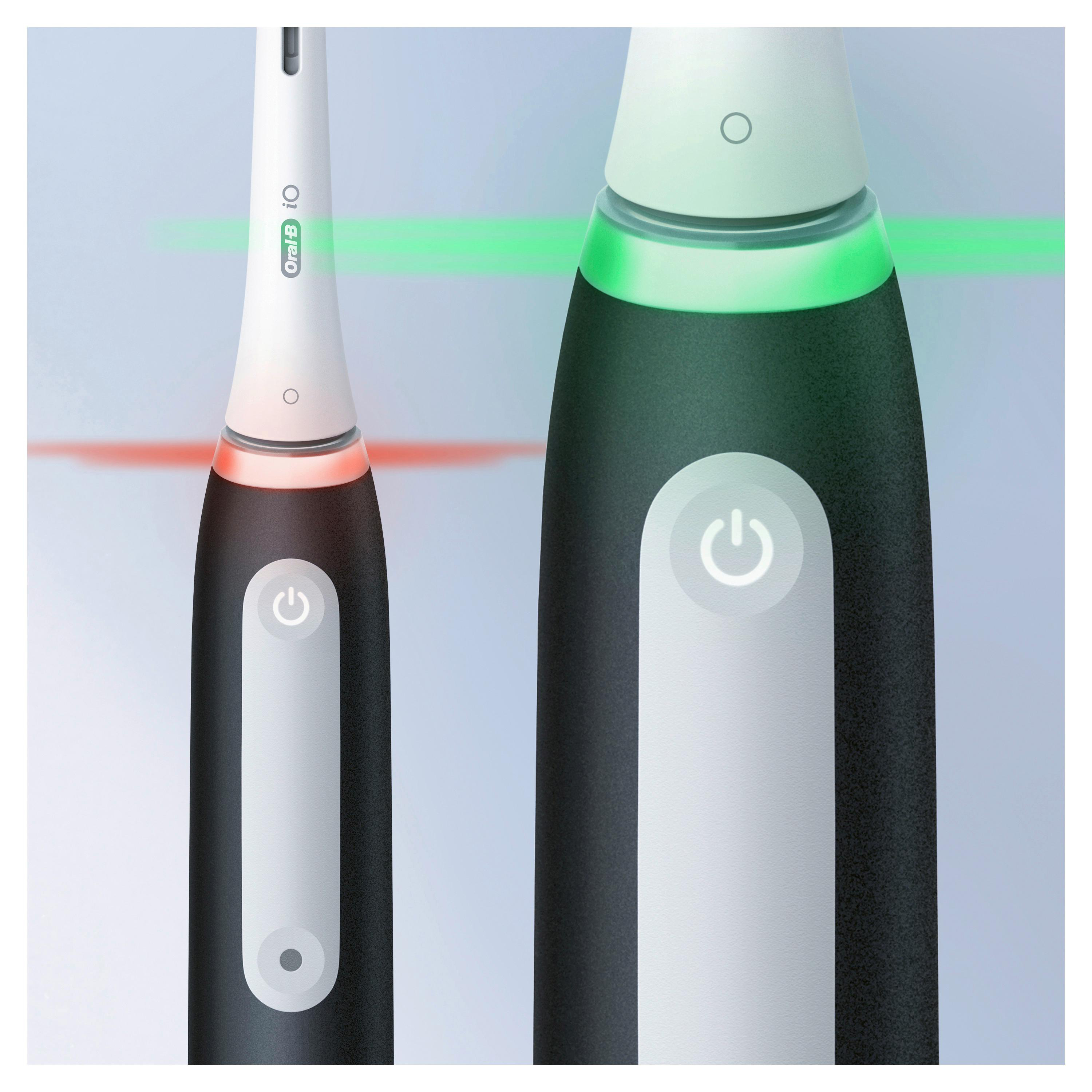 Zwei elektrische Zahnbürsten, eine mit rotem Licht und eine mit grünem Licht am Bürstenkopf.