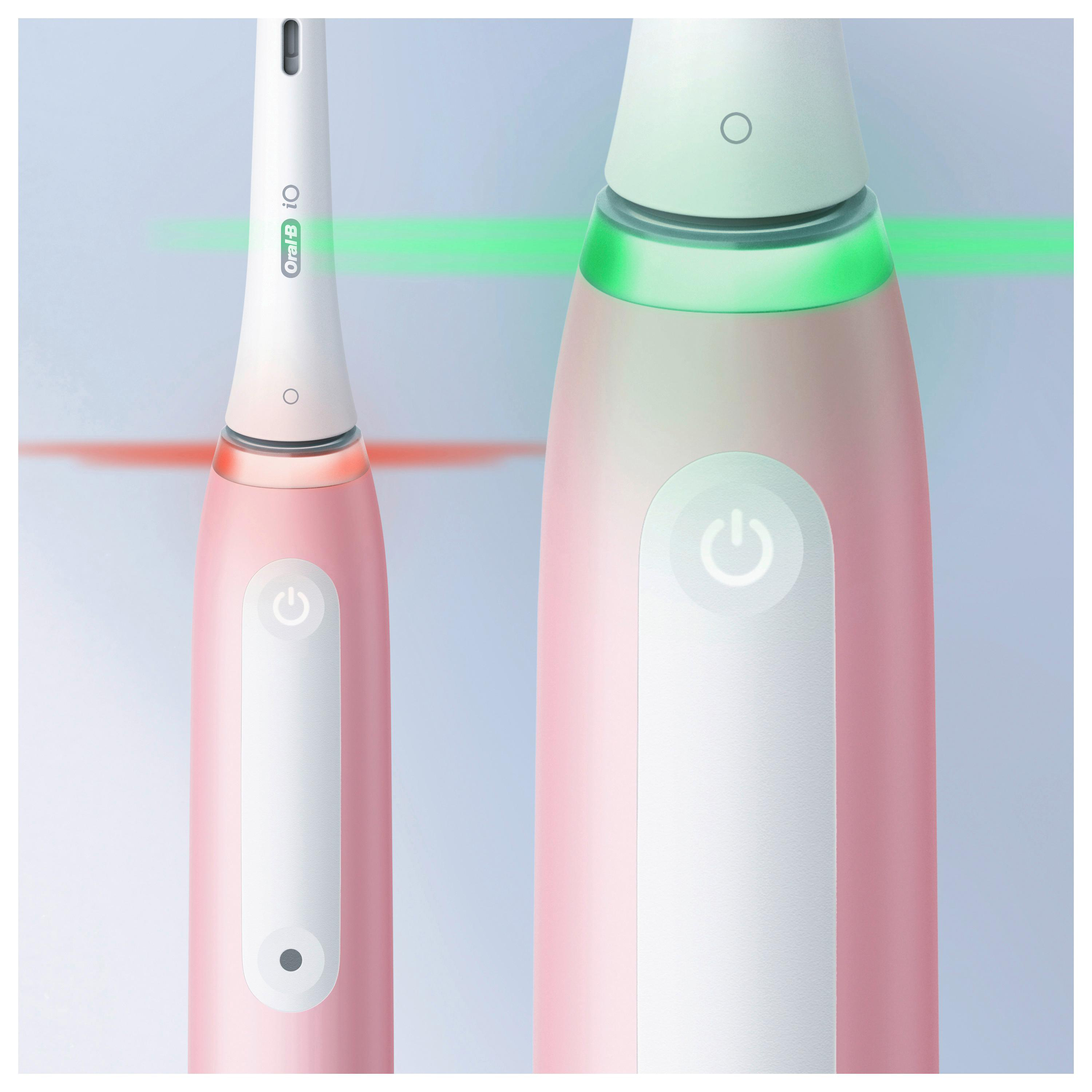 Zwei elektrische Zahnbürsten, eine rosa, eine weiß, mit grünen und roten Lichtern.