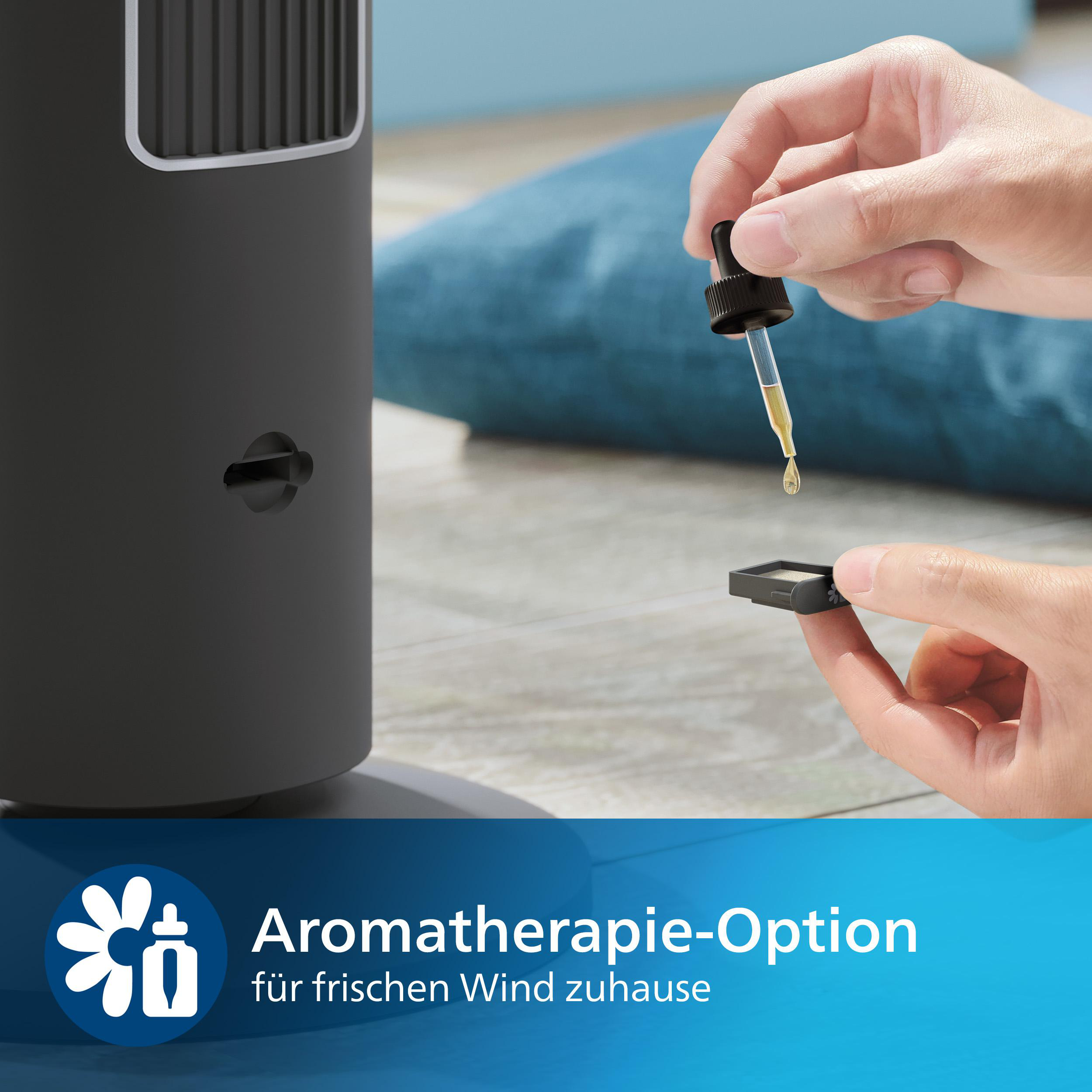 Die Hand einer Person, die eine Pipette mit gelber Flüssigkeit über einem kleinen schwarzen Behälter hält, in der Nähe eines schwarzen Ventilators.
