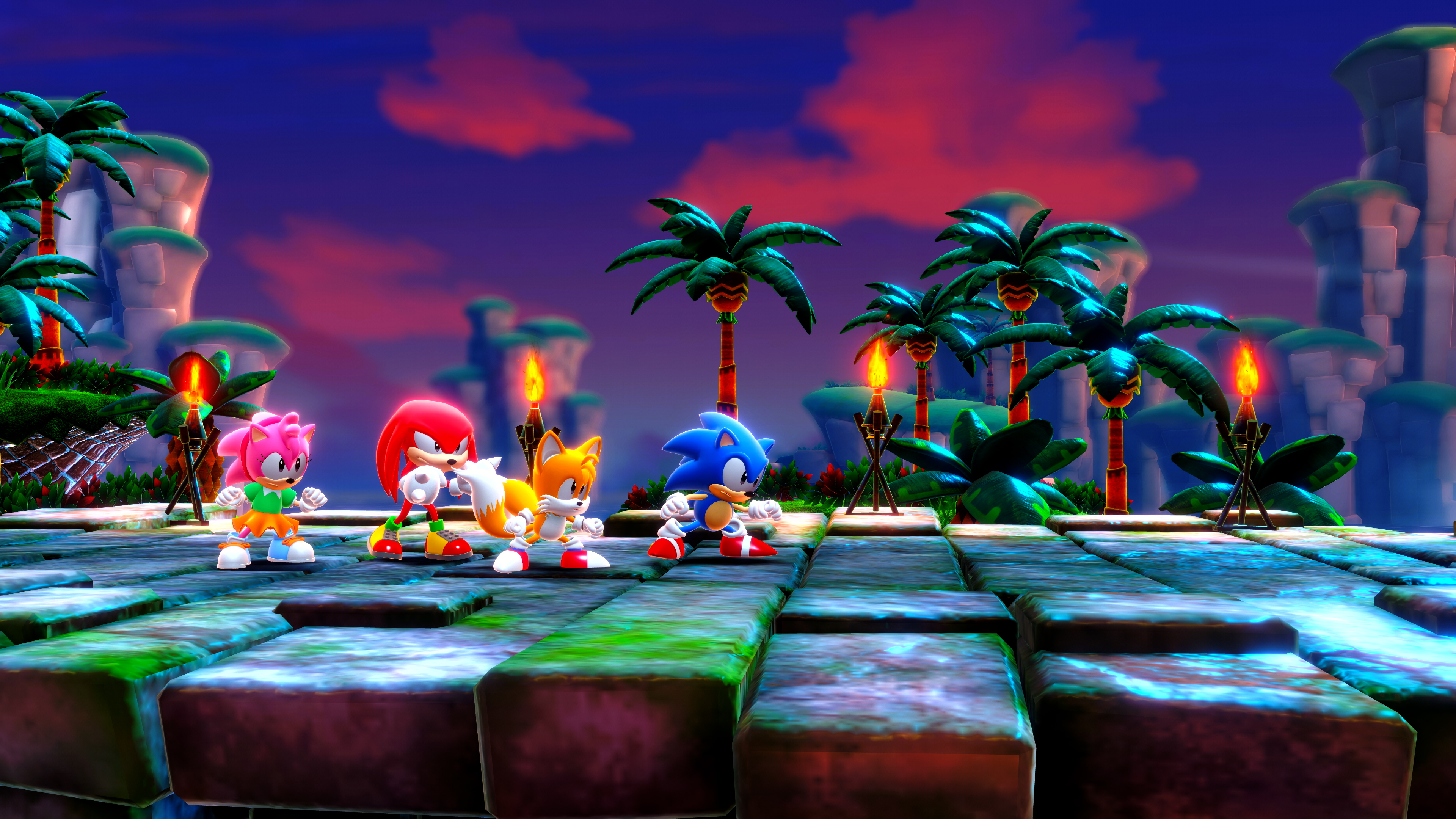 Sonic et ses amis sont sur une plateforme, des palmiers en arrière-plan, avec un ciel de coucher de soleil vibrant.