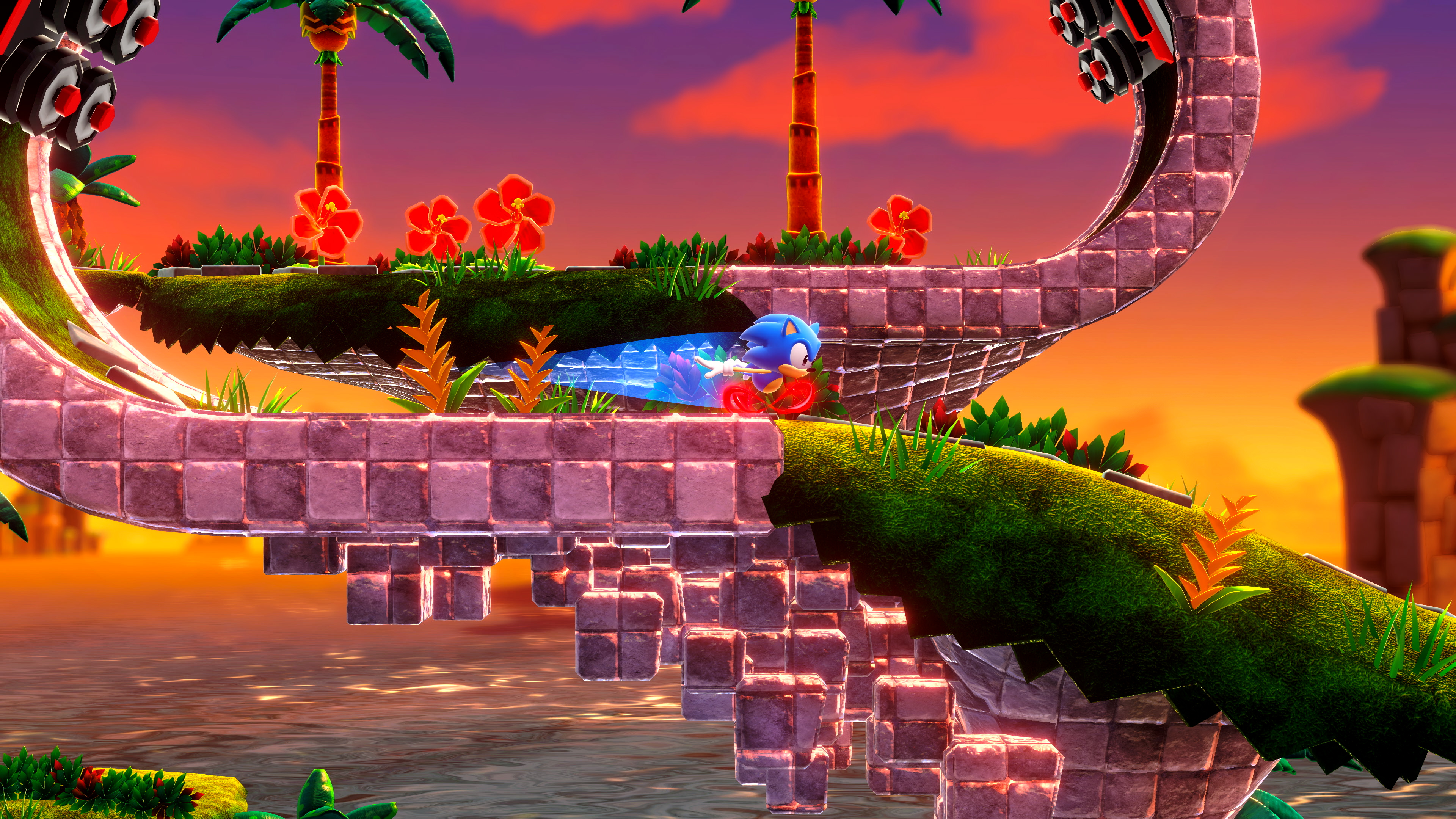 Sonic corre su un sentiero di mattoni, in un livello di gioco, con palme e cielo al tramonto.