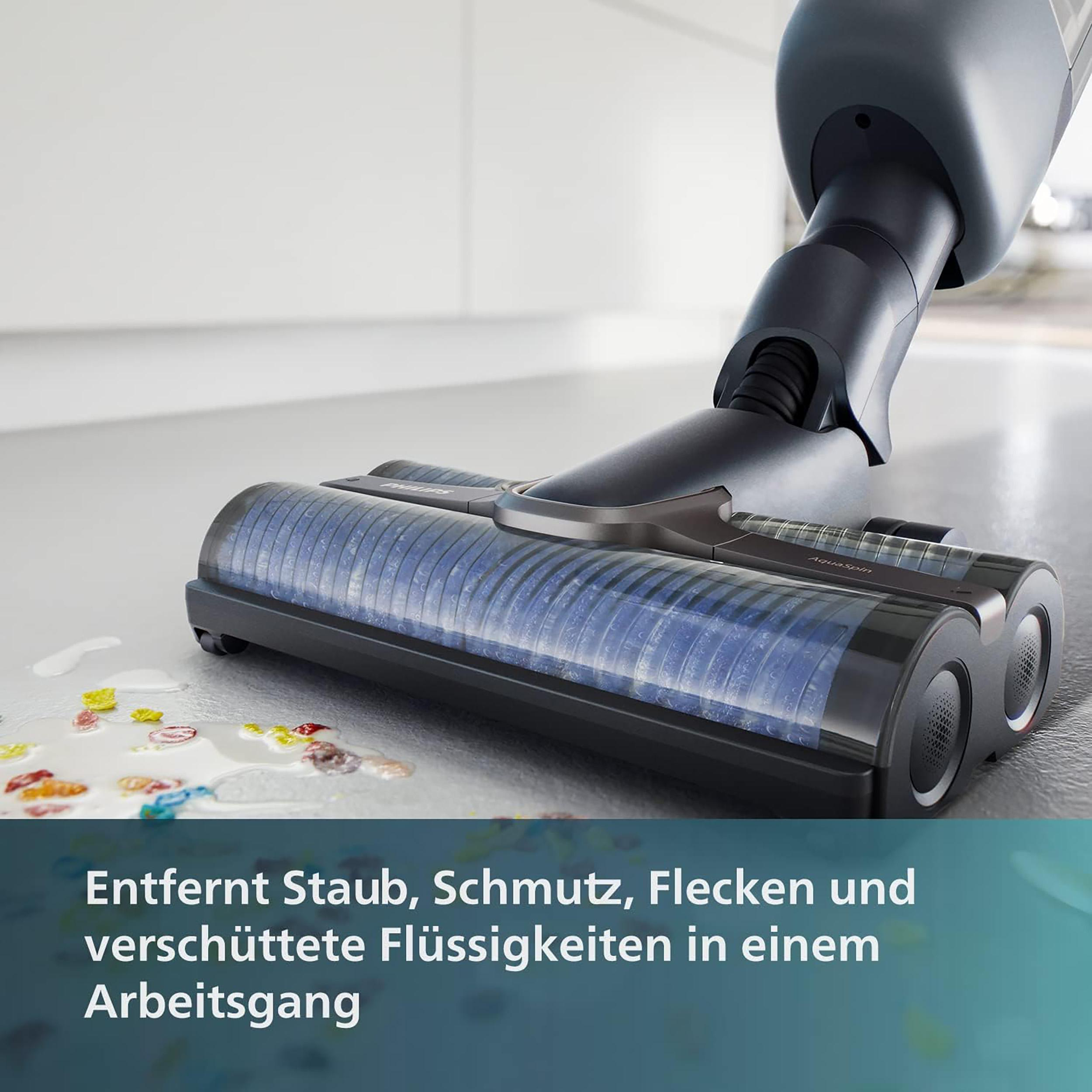 Staubsaugerkopf reinigt verschüttete Flüssigkeiten und Rückstände auf einer hellgrauen Oberfläche.