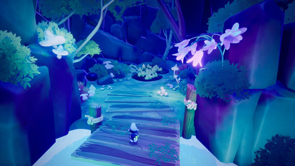 Scena z leśnej fantazji. Drewniany most i ścieżka prowadzą przez świecące, niebiesko oświetlone drzewa i grzyby.