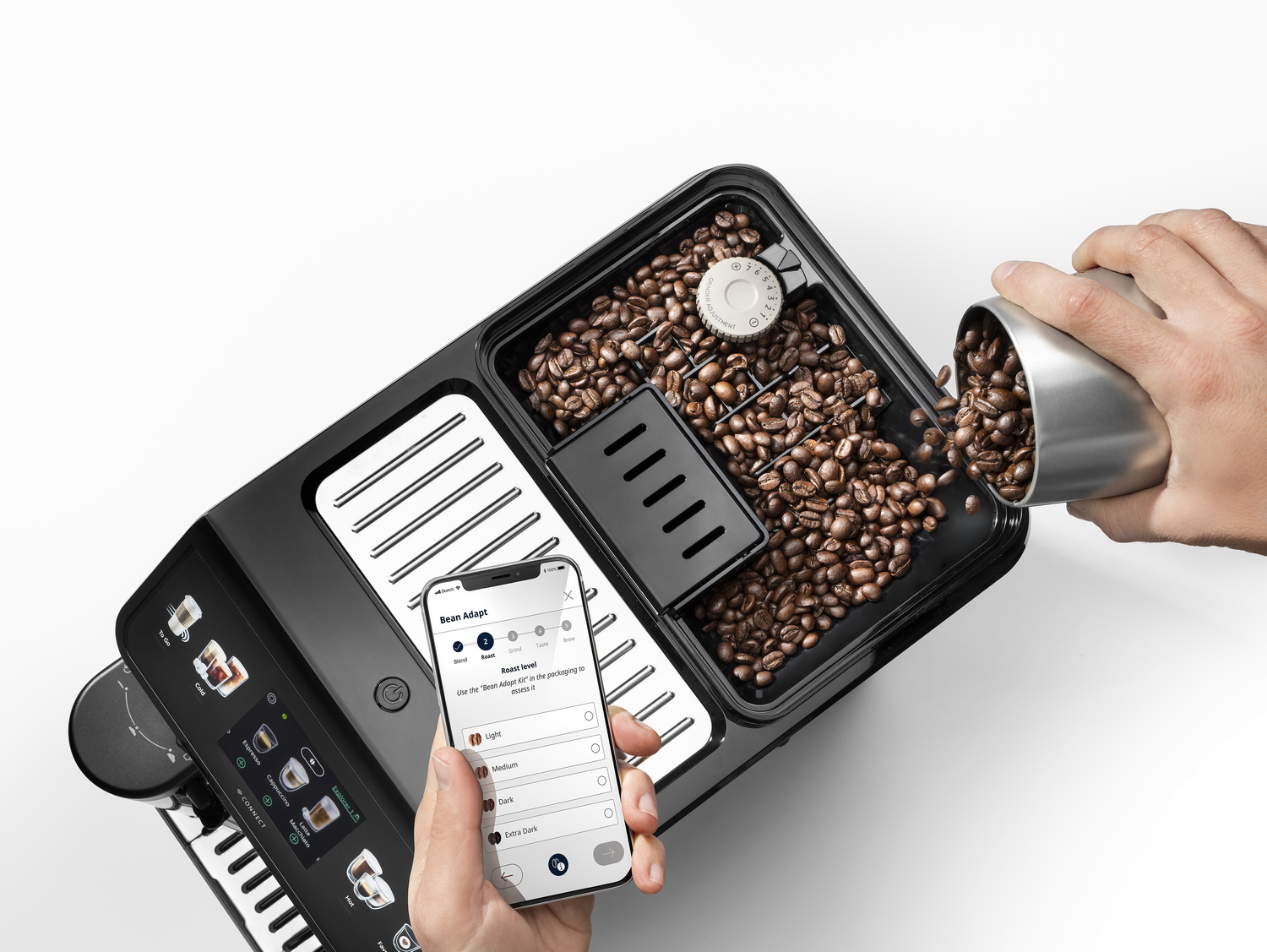 Cafetera con granos y un teléfono mostrando opciones de tipos de granos.