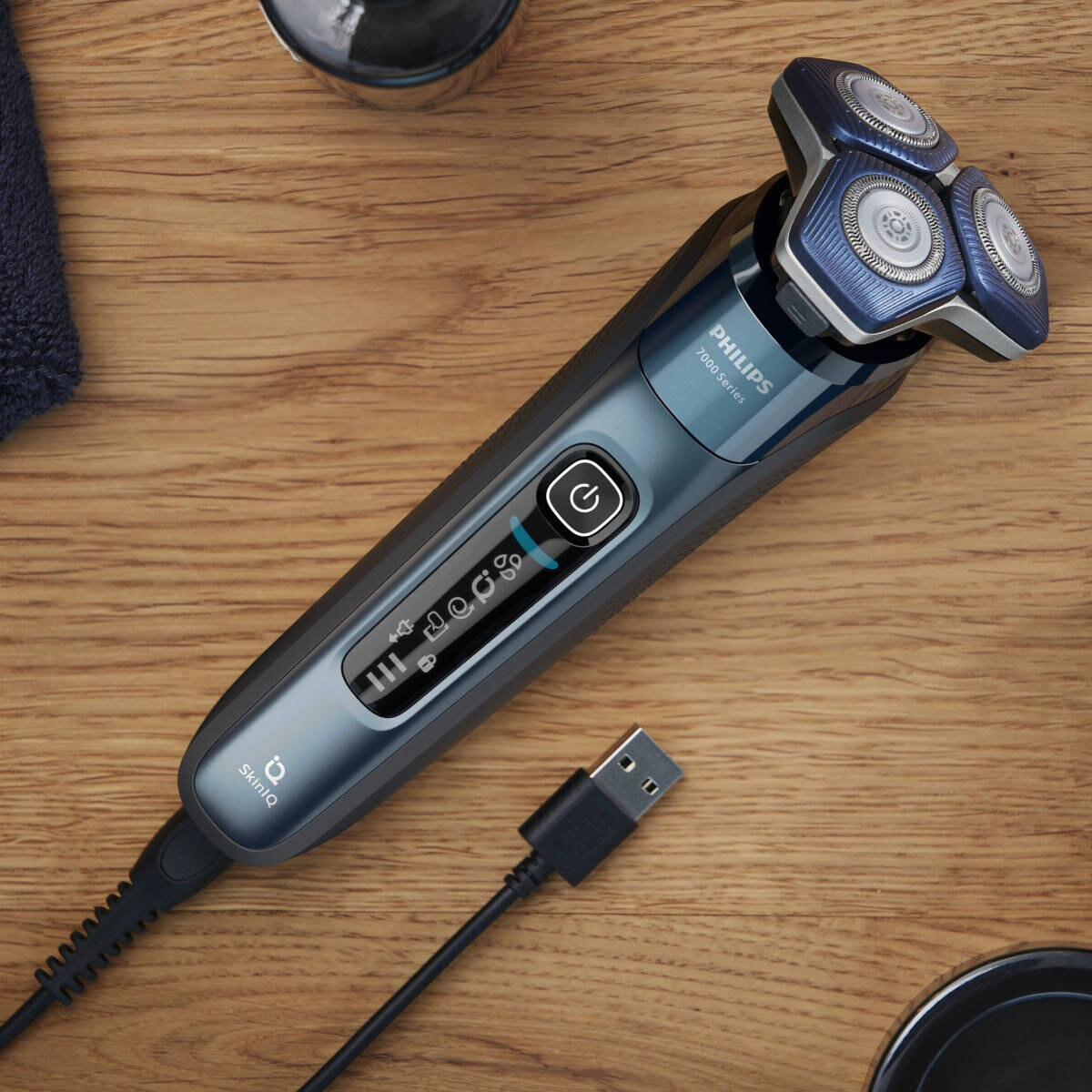 Golarka elektryczna Philips na drewnianej powierzchni, podłączony kabel USB.