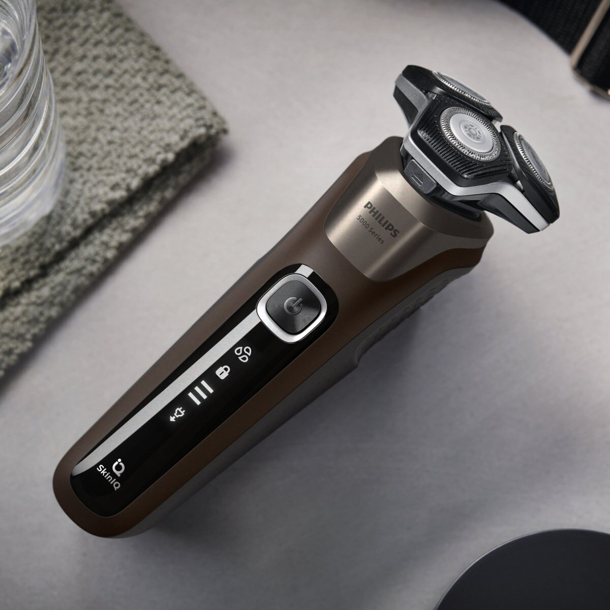 Golarka Philips serii 5000, brązowa i czarna, leżąca na szarej powierzchni.