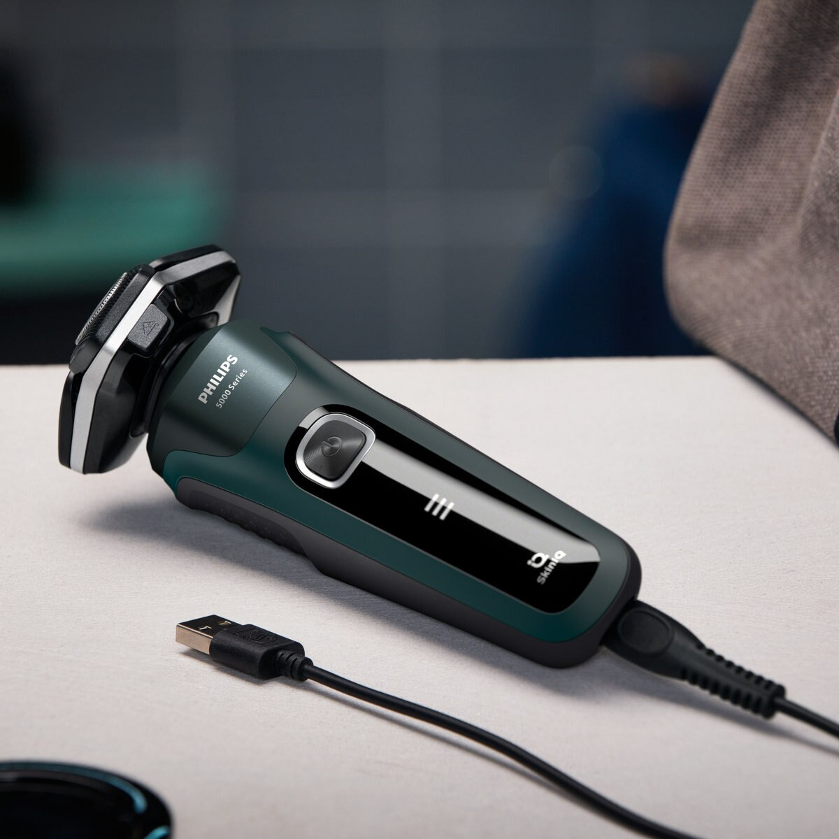 Golarak elektryczna z podłączonym kablem do ładowania USB, na jasnej powierzchni.