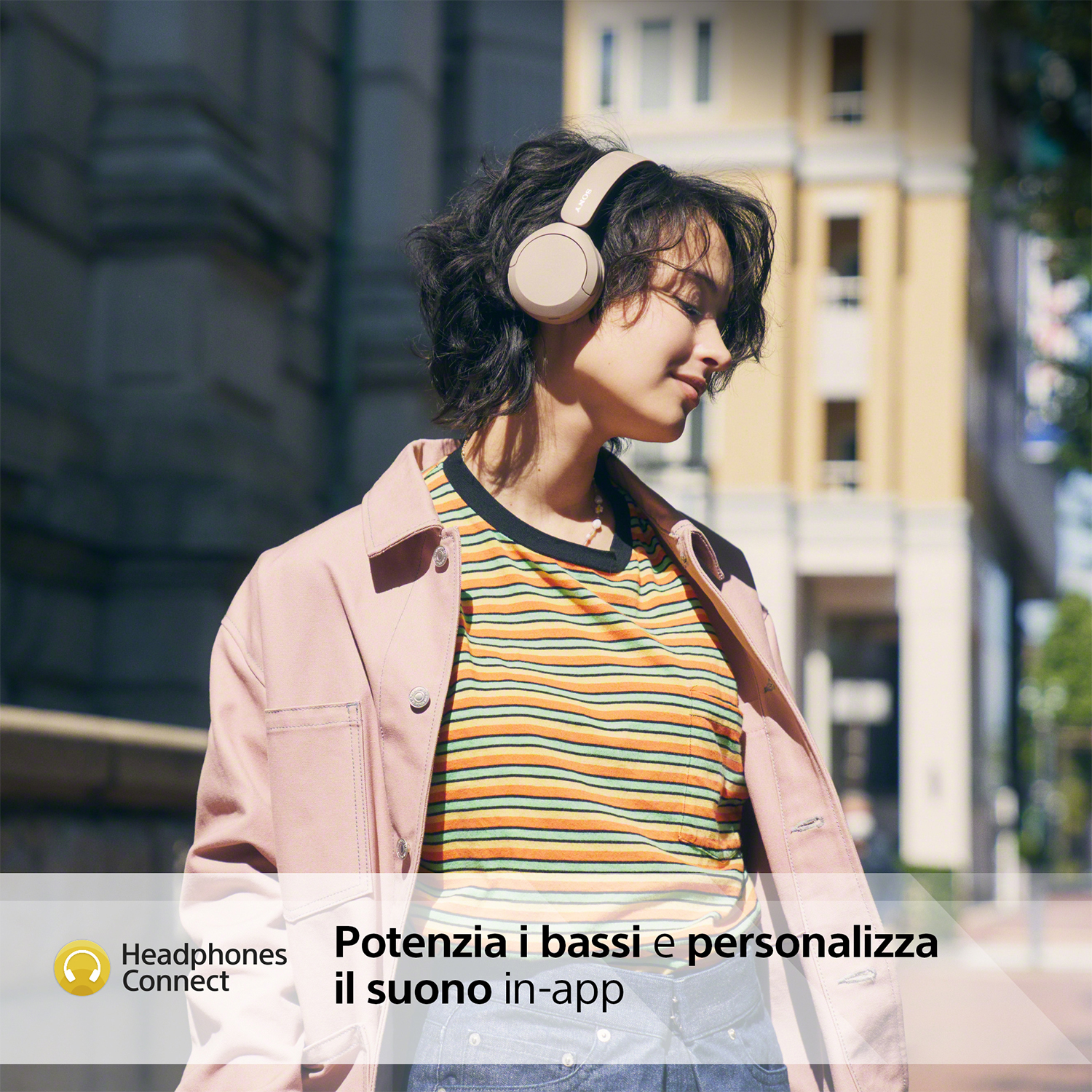 Donna con le cuffie, cammina per strada, testo: 'Collega le cuffie'.